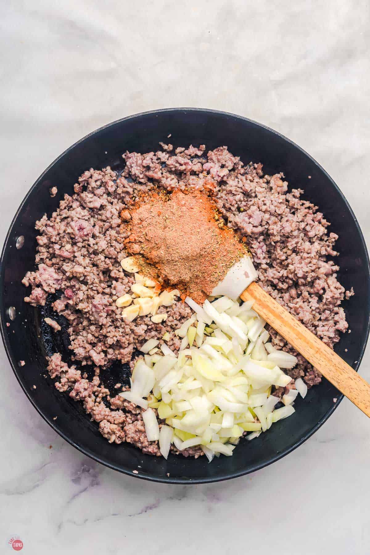 ground beef and onions cooking in a skillet