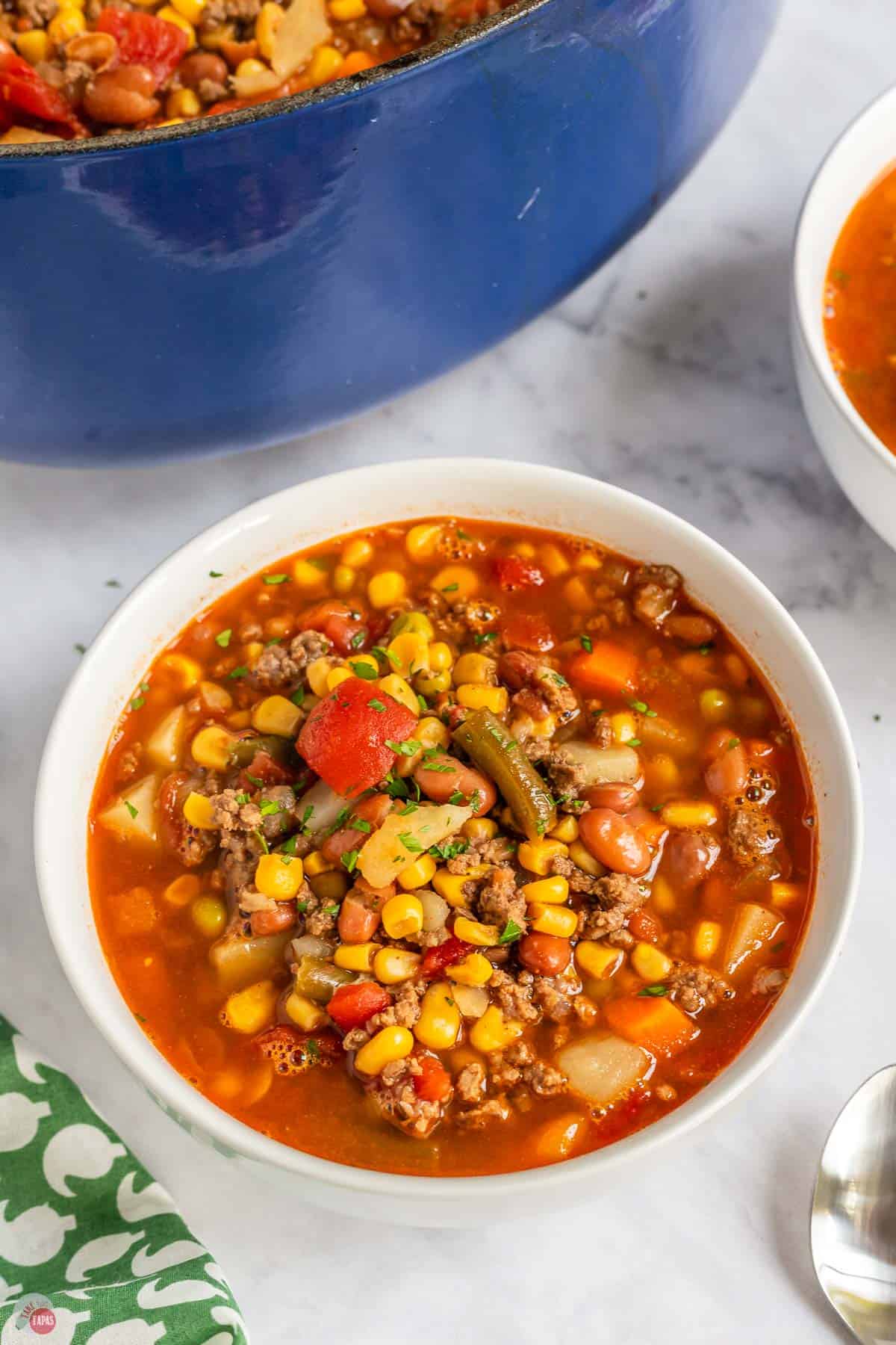 bowl of cowboy soup next to a blue pot