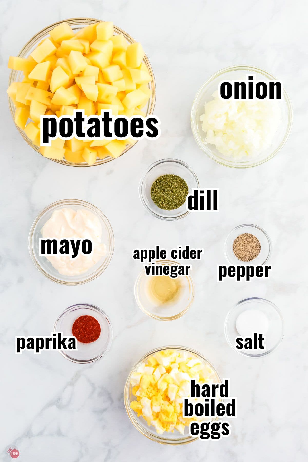 ingredients for potato salad recipe in individual bowls with text overlay labeling them