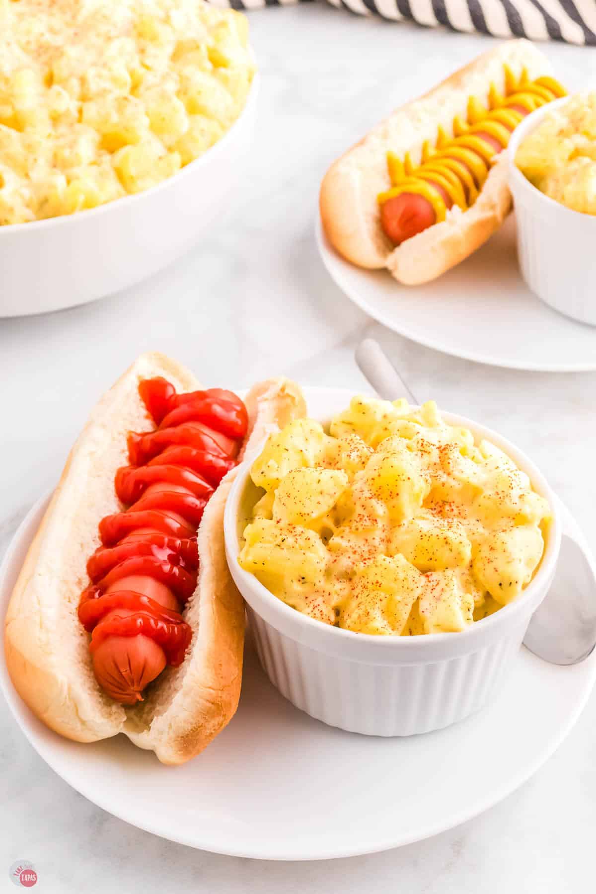 hot dog topped with ketchup and a side of potato salad