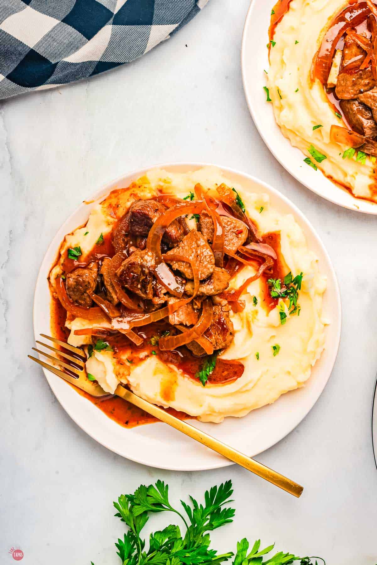plate of mashed potatoes and steak topped with gravy