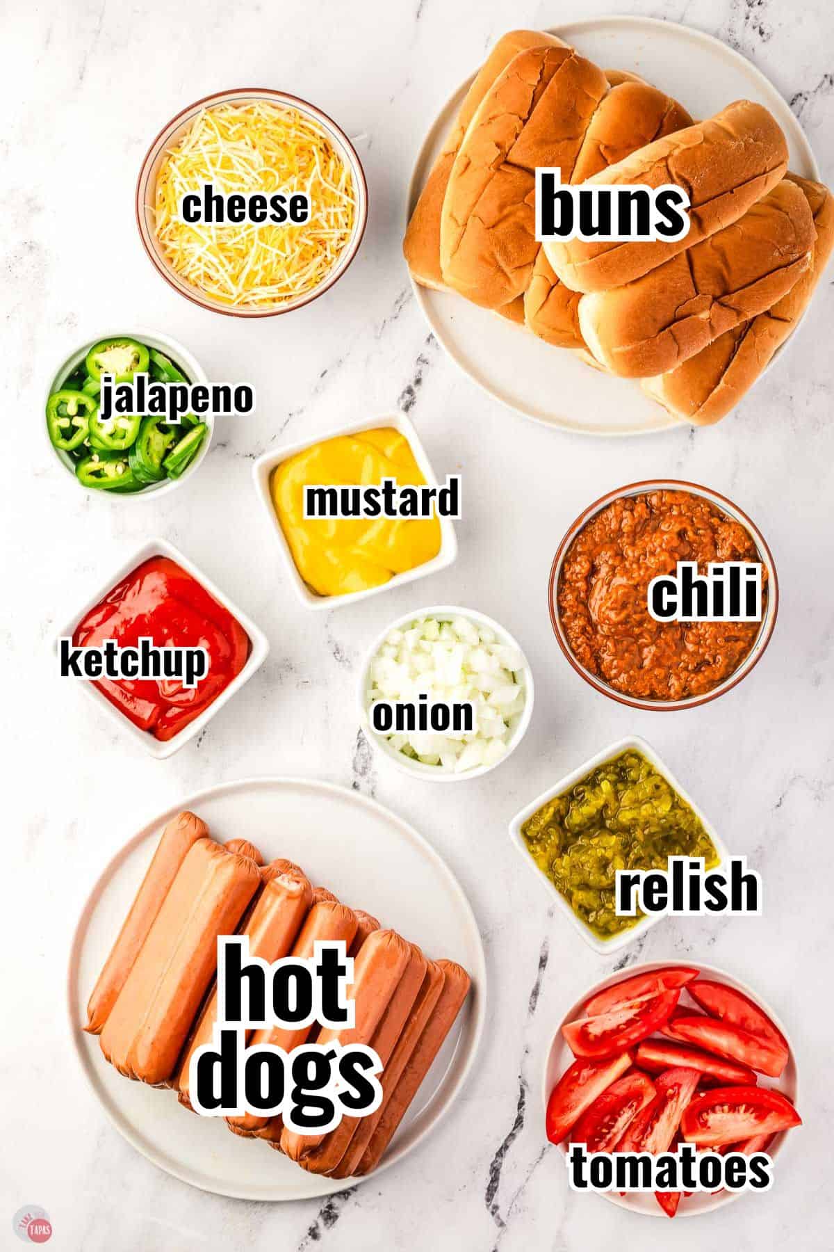 Hot dogs, buns, and condiments on a marble surface