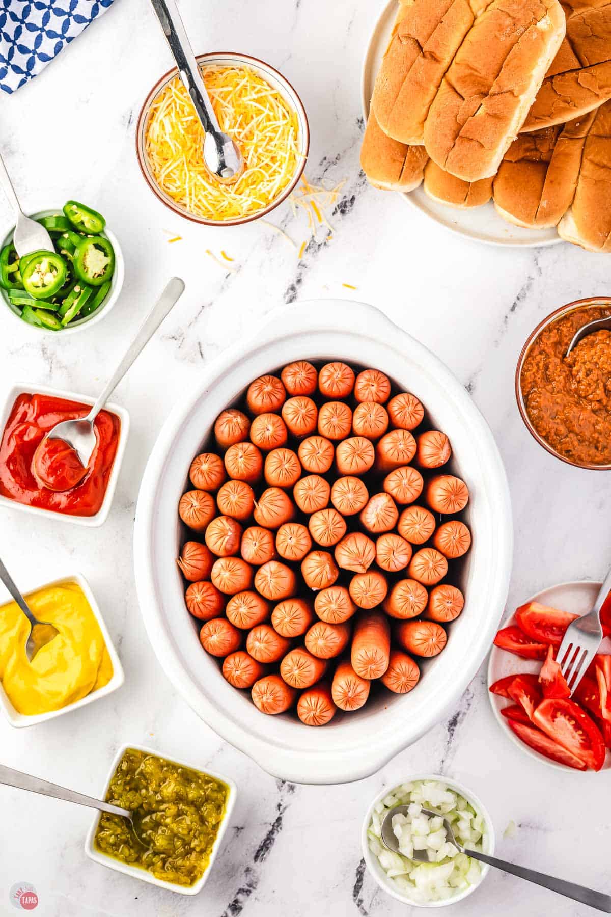 items for a hot dog bar on a marble counter