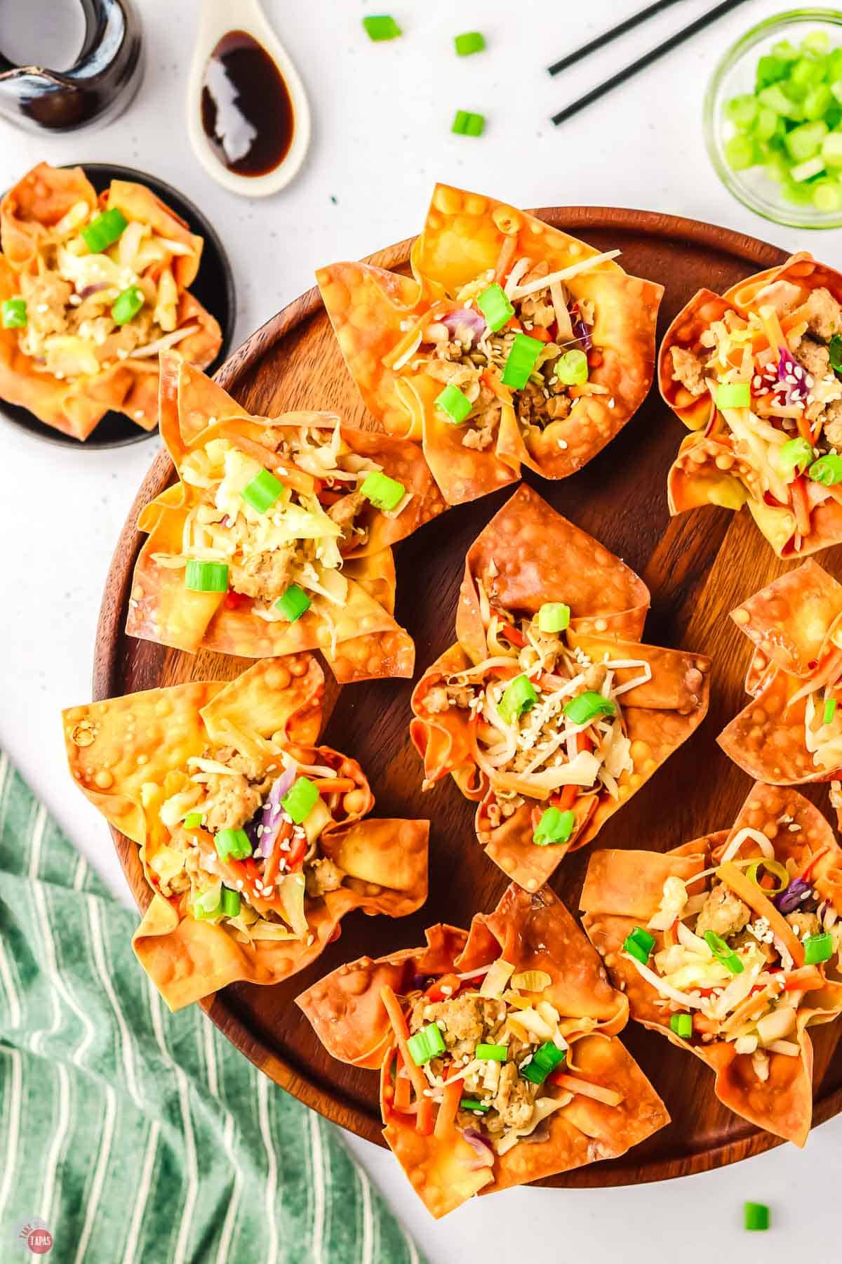 overhead picture of egg roll cups on a round wood cutting board