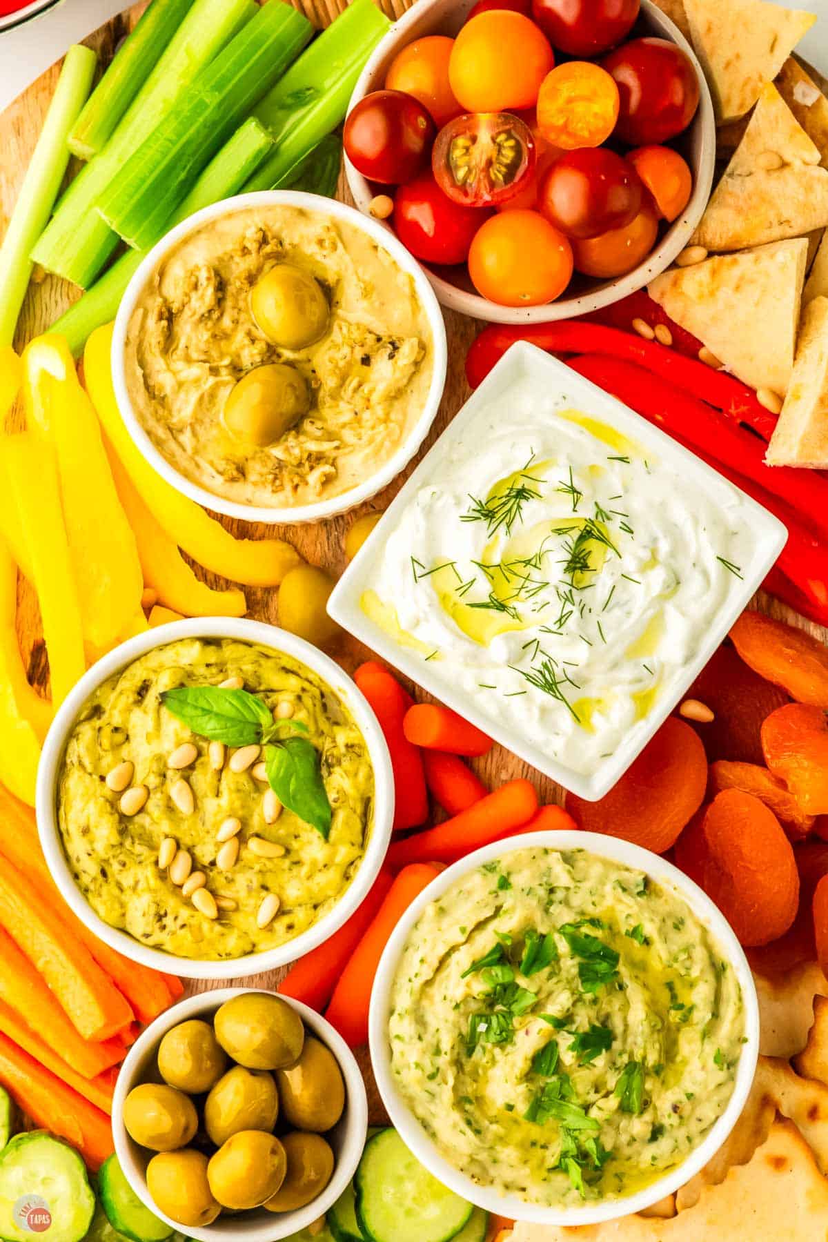 bowls of dip surrounded by sliced vegetables