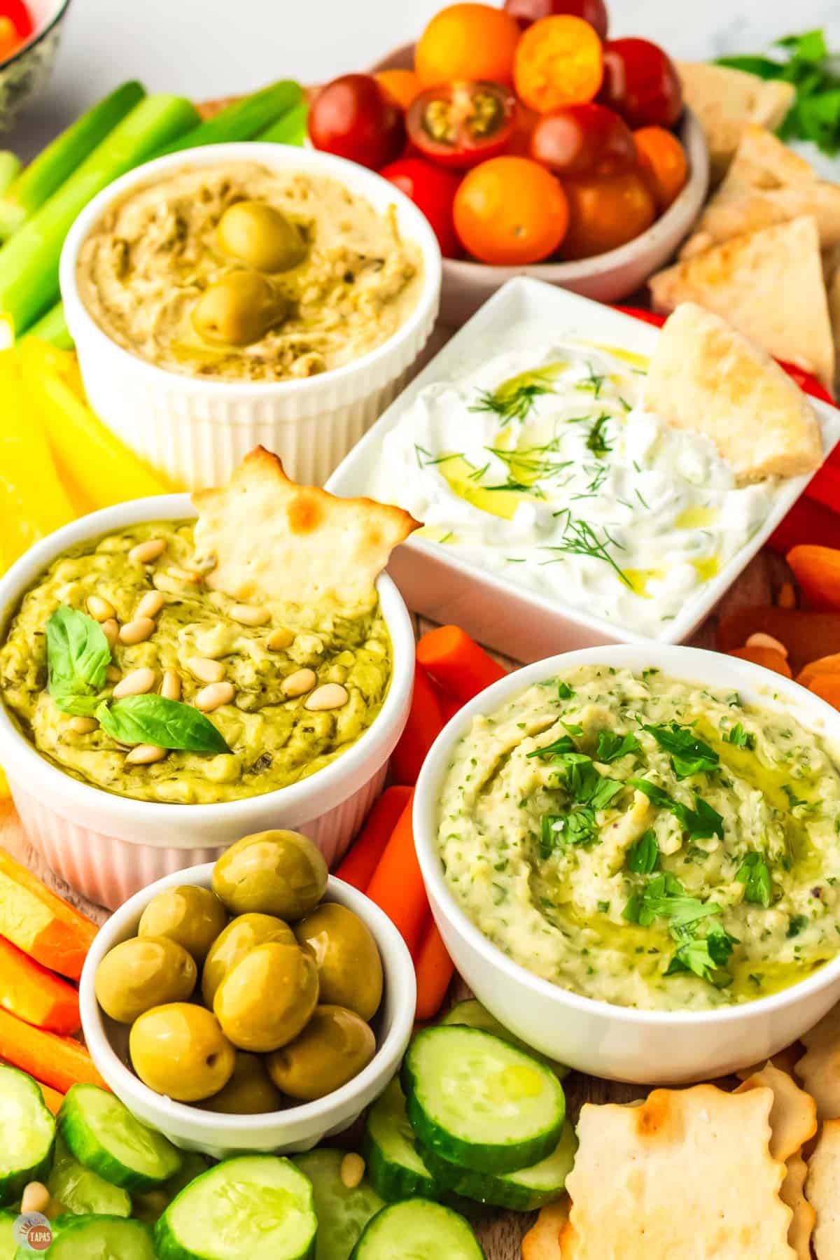 side angle of mezze platter with bowls of hummus and tzatziki