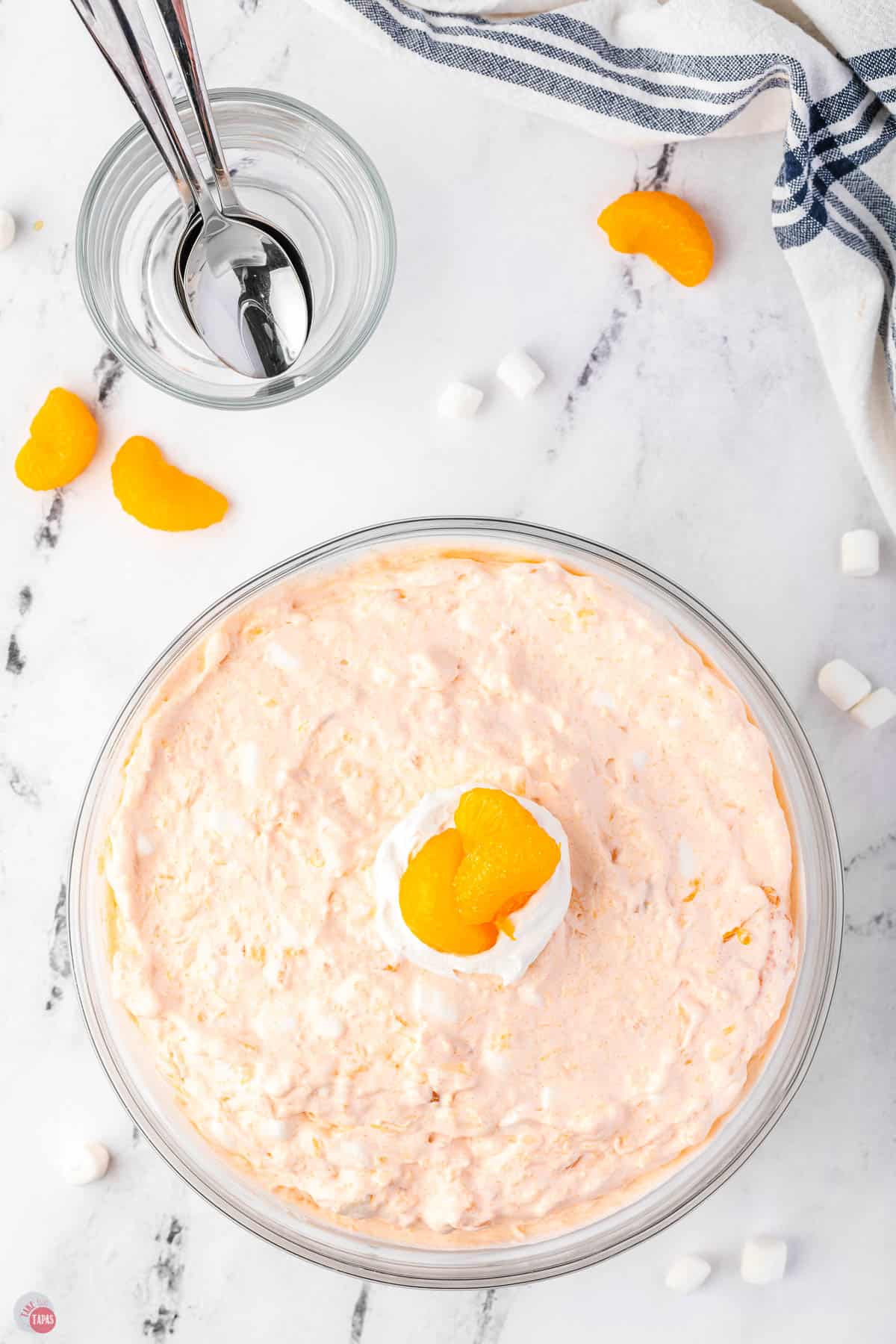 orange fluff jello salad in a clear bowl