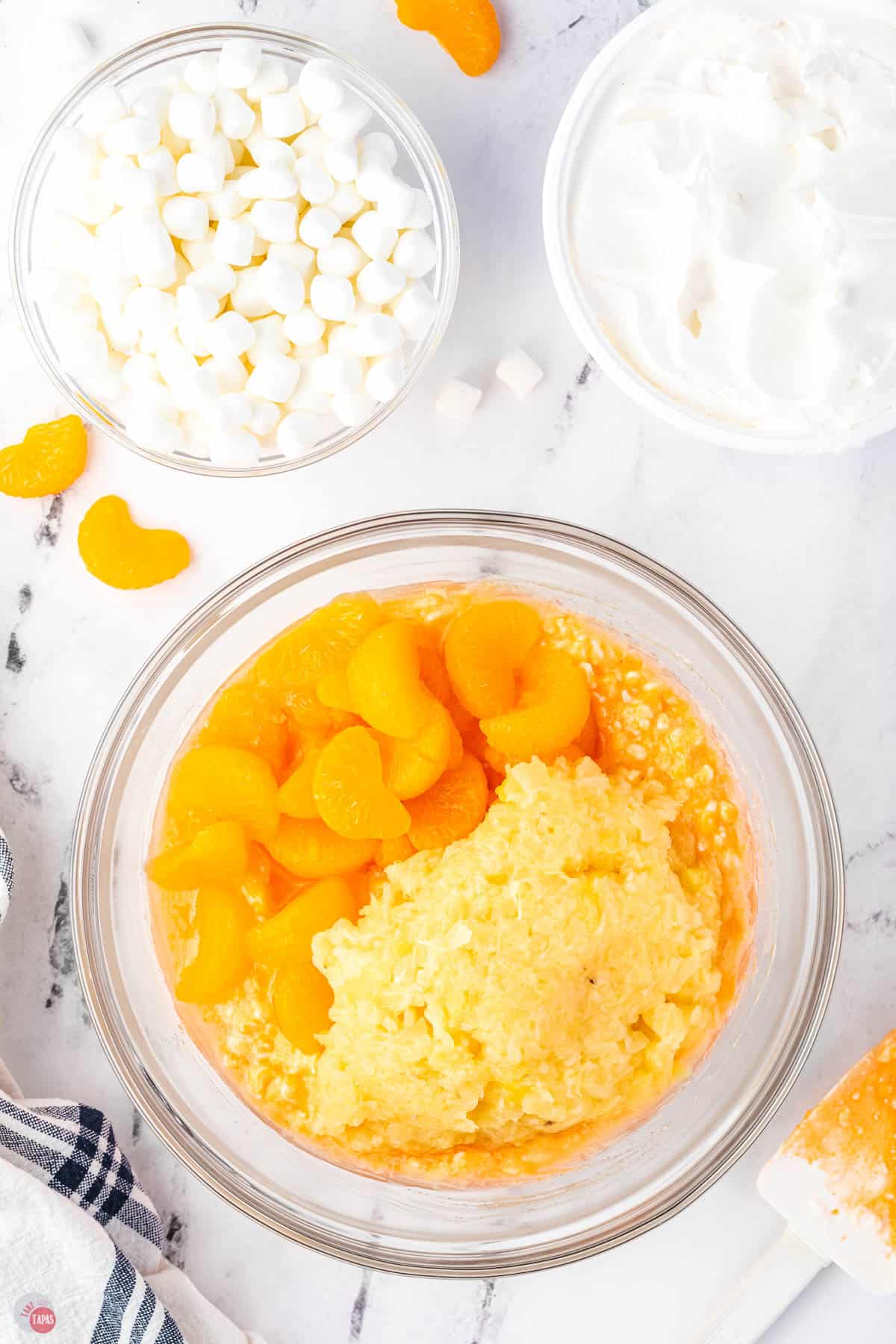 oranges and crushed pineapple in a clear bowl