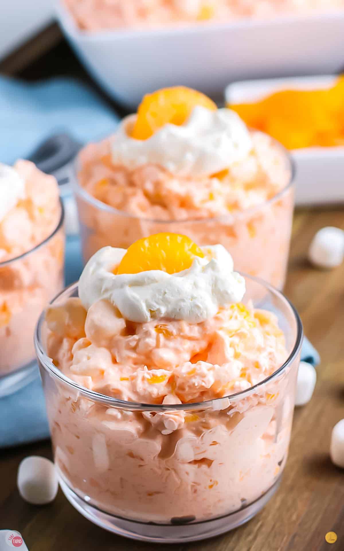 close up of orange fluff jello salad in small glass bowls