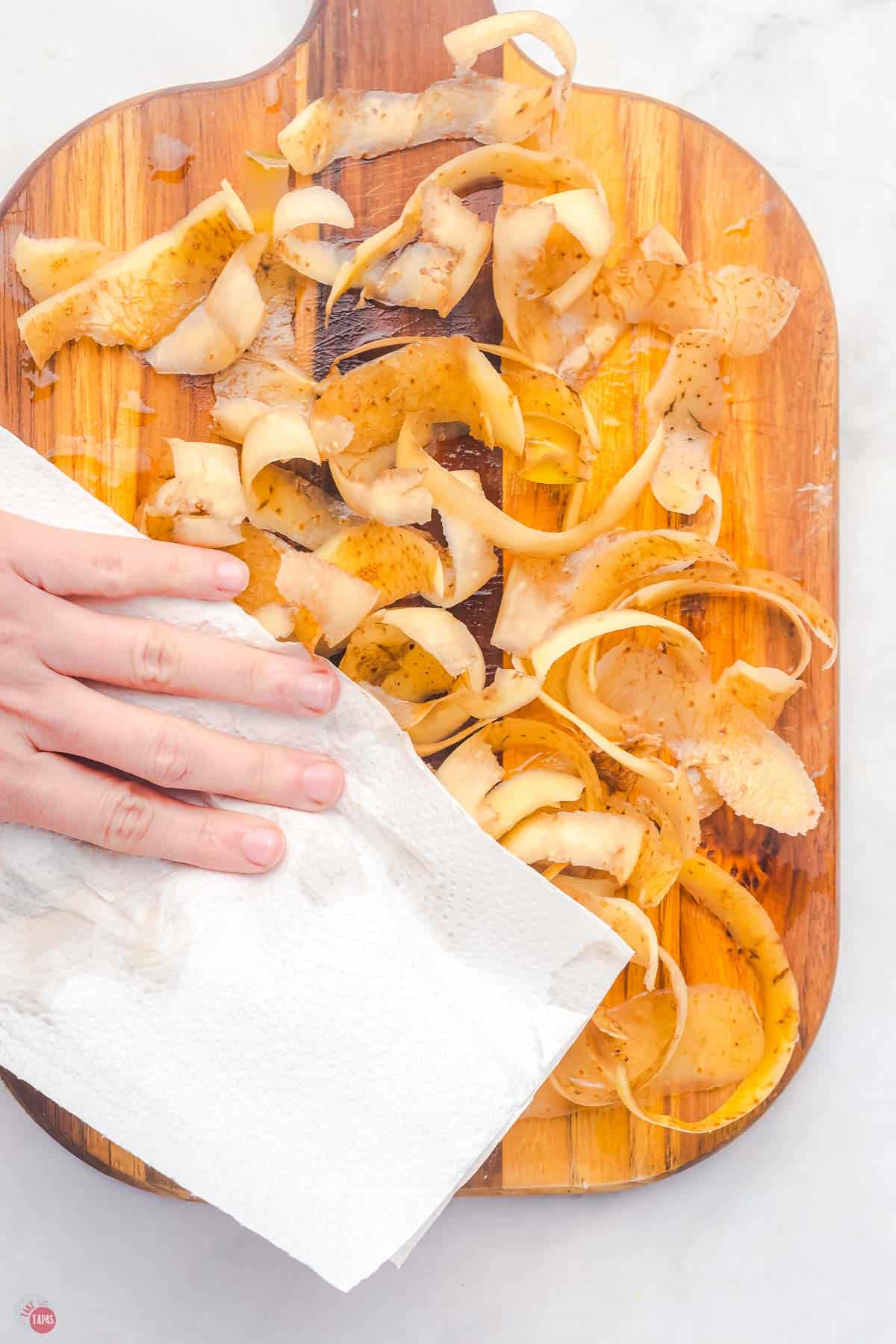 potato peels being dried with a paper towel