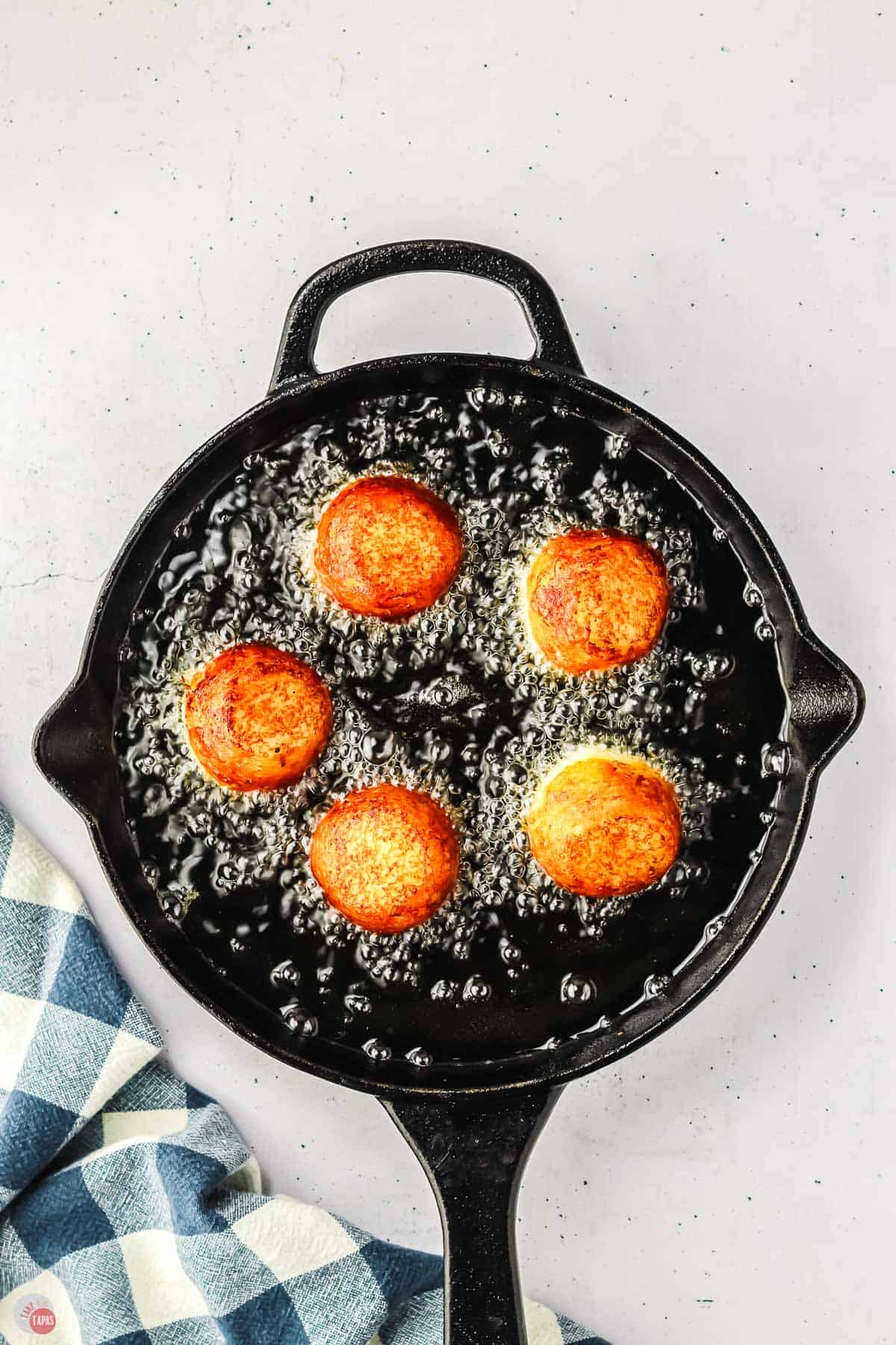 potato poutine frying in a cast iron skillet