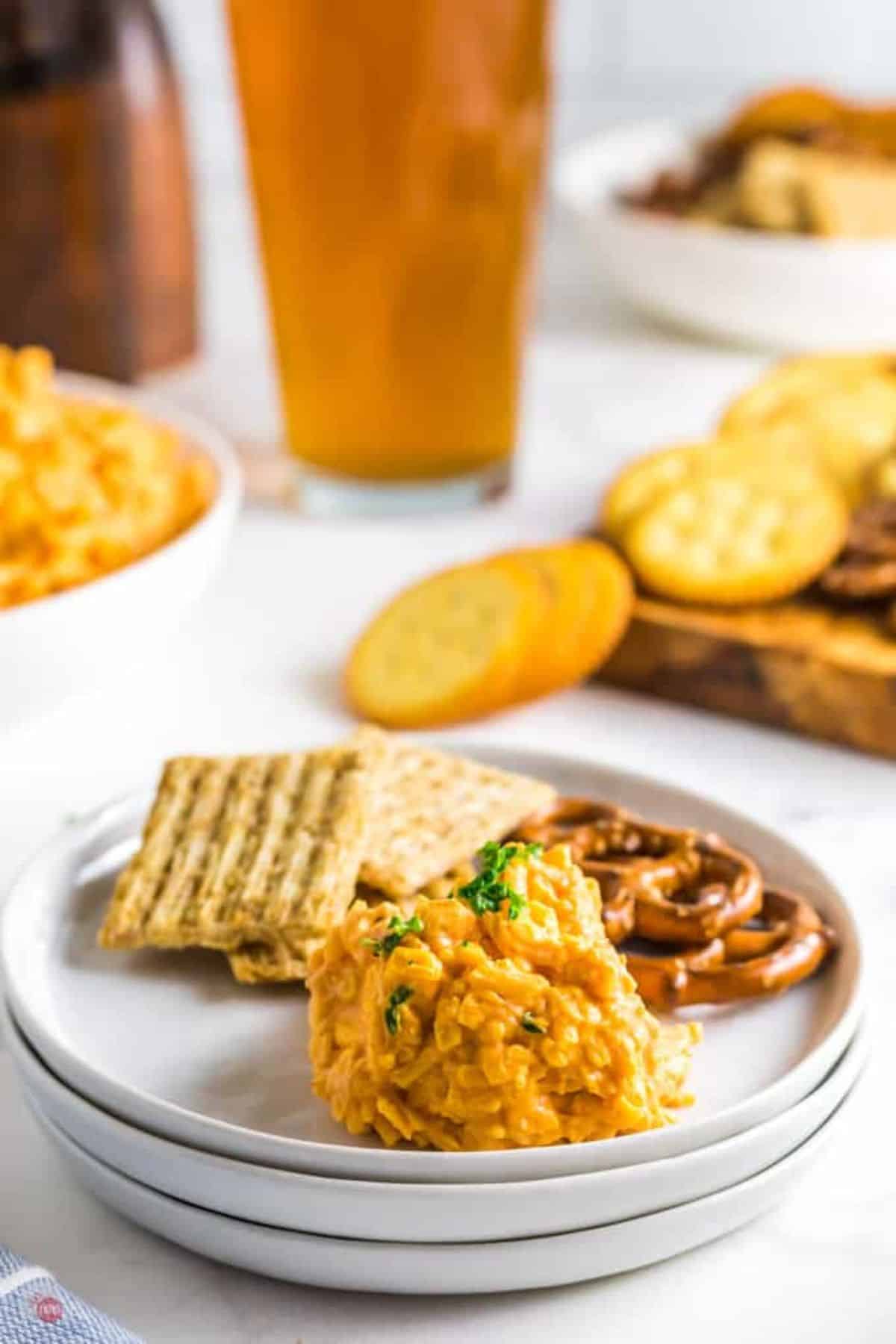 stack of plates with crackers, pretzels, and pub cheese