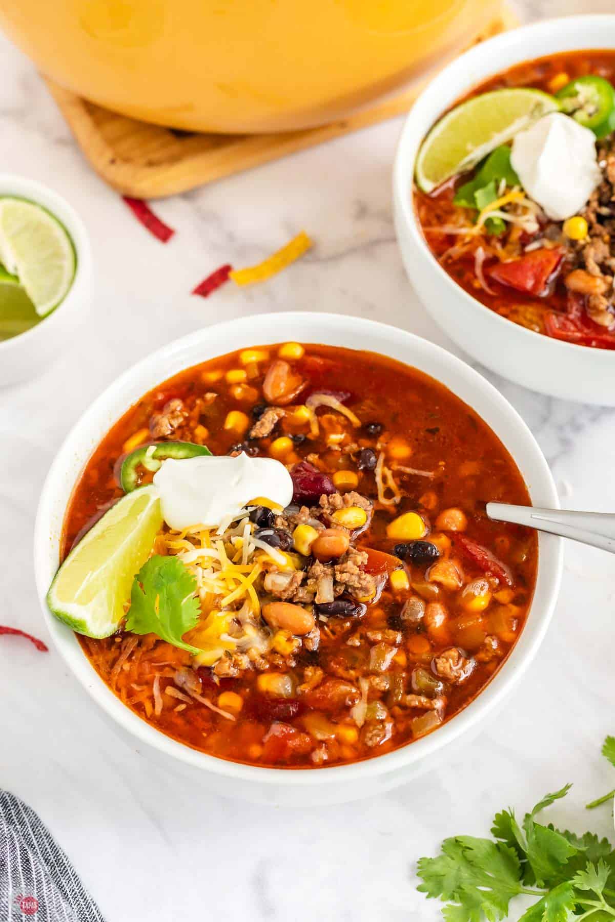 bowl of santa fe soup in two bowls in front of a yellow pot