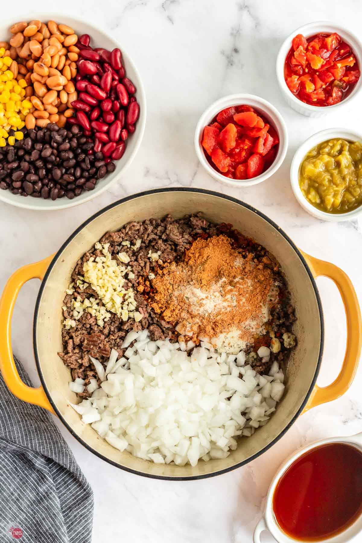 cooked ground beef, onions, and spices in a yellow pot