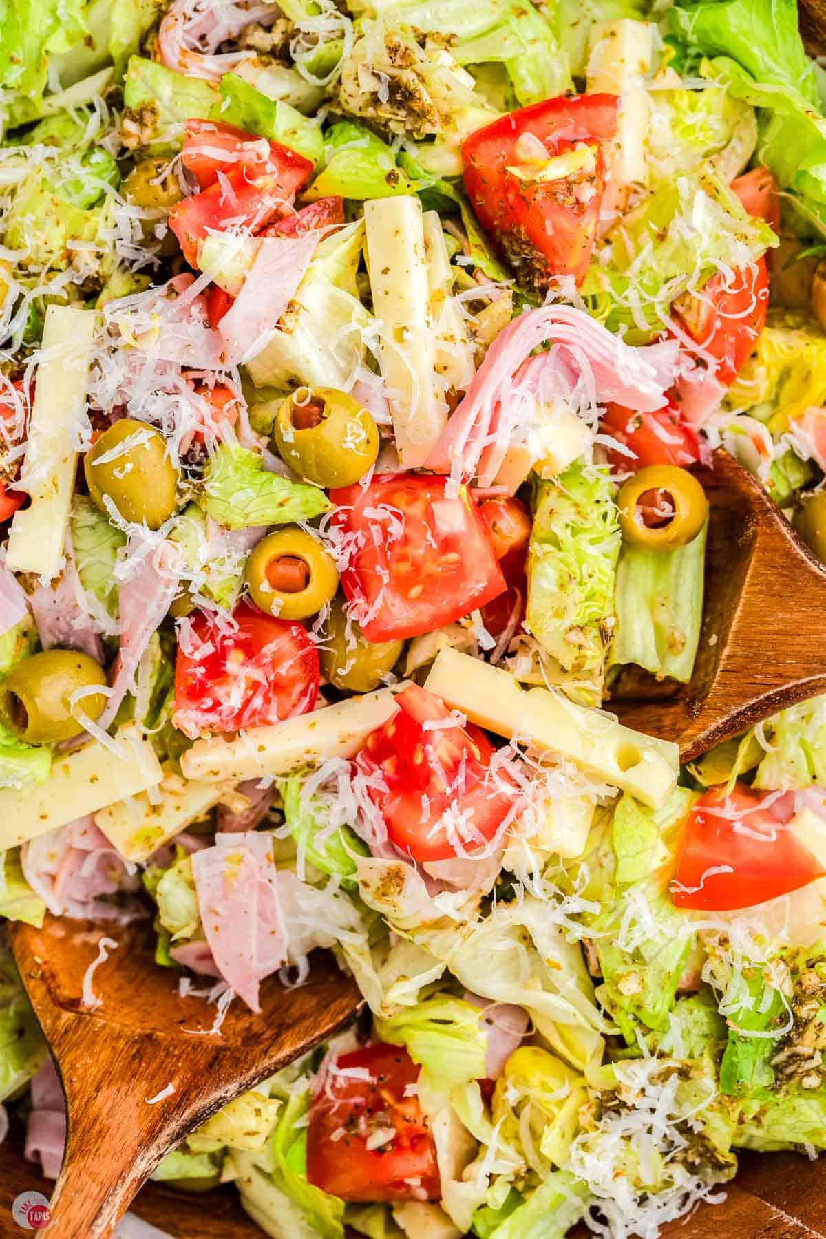 A salad with tomatoes, olives, and cheese.