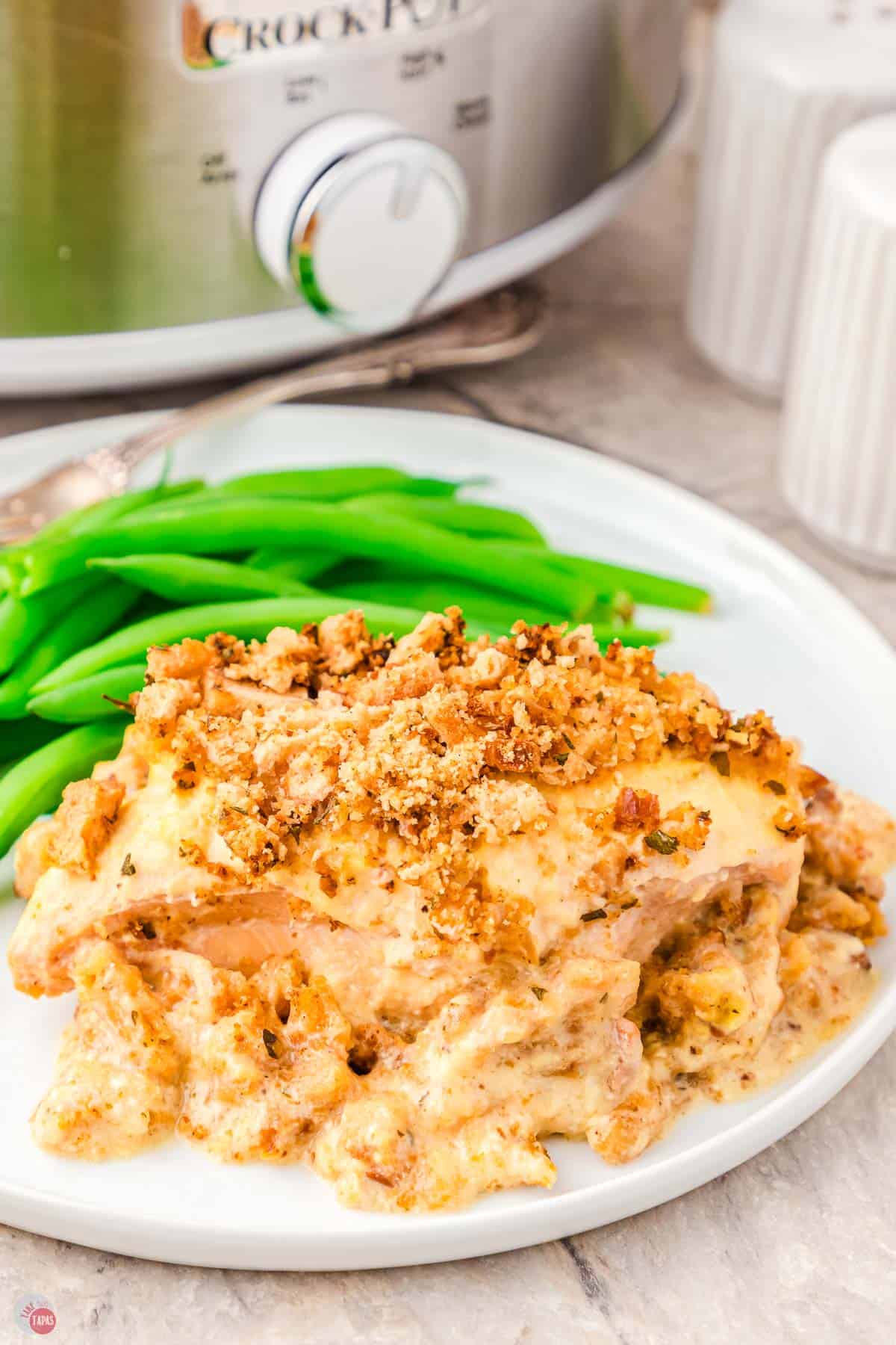 close up of chicken and stuffing on a plate with green beans