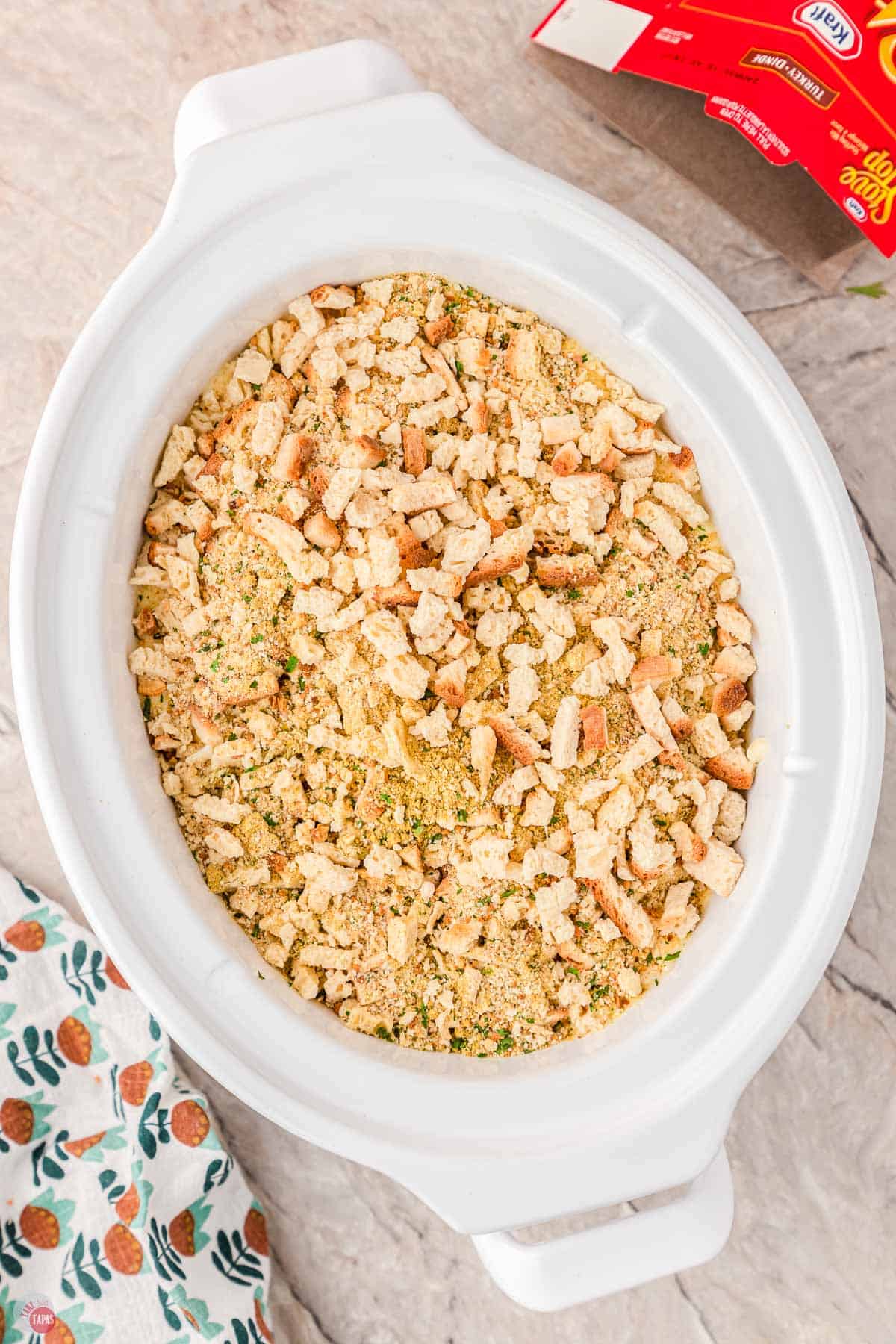 white crockpot filled with dry stuffing mixture