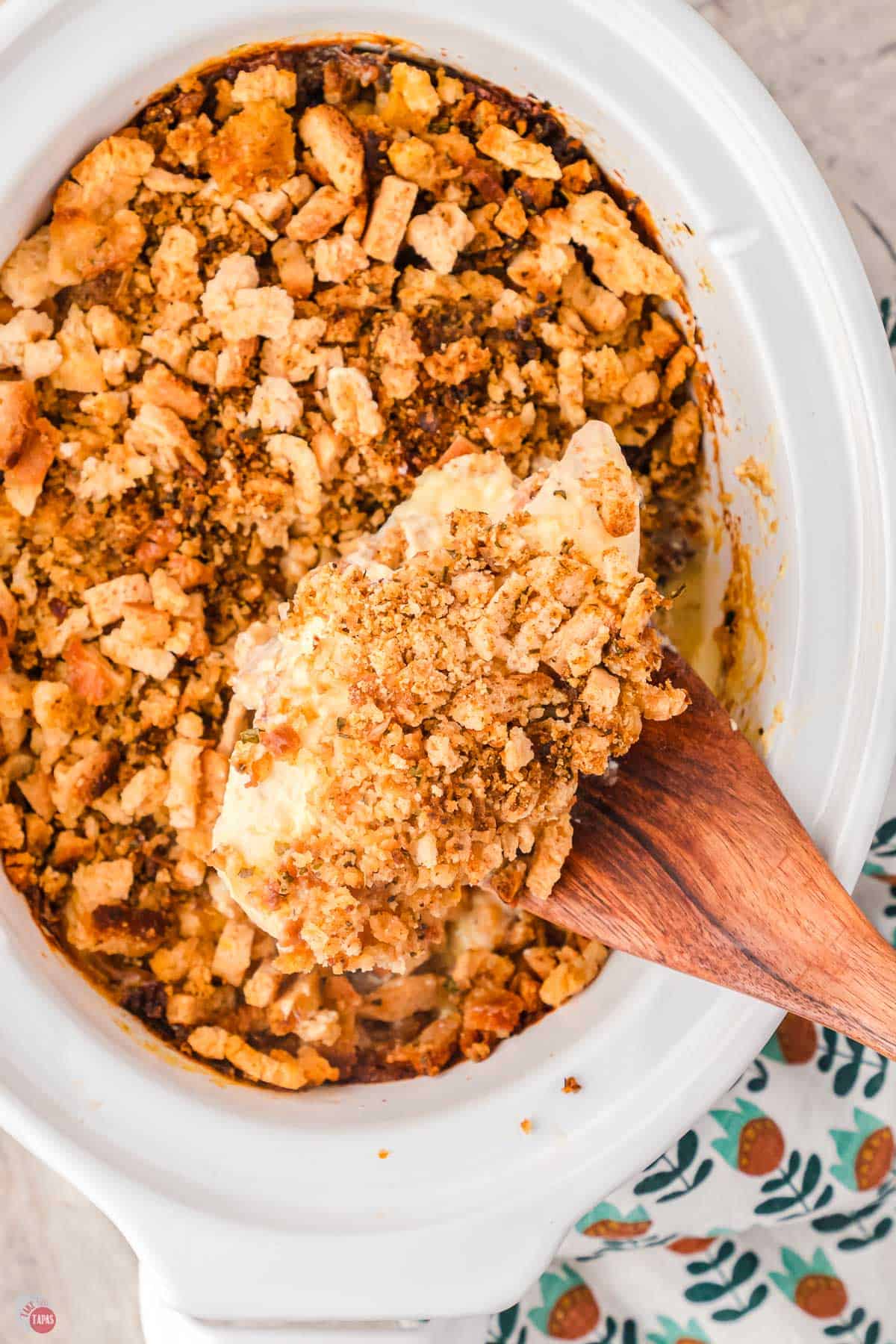 wood spoon scooping chicken and dressing out of a white dish