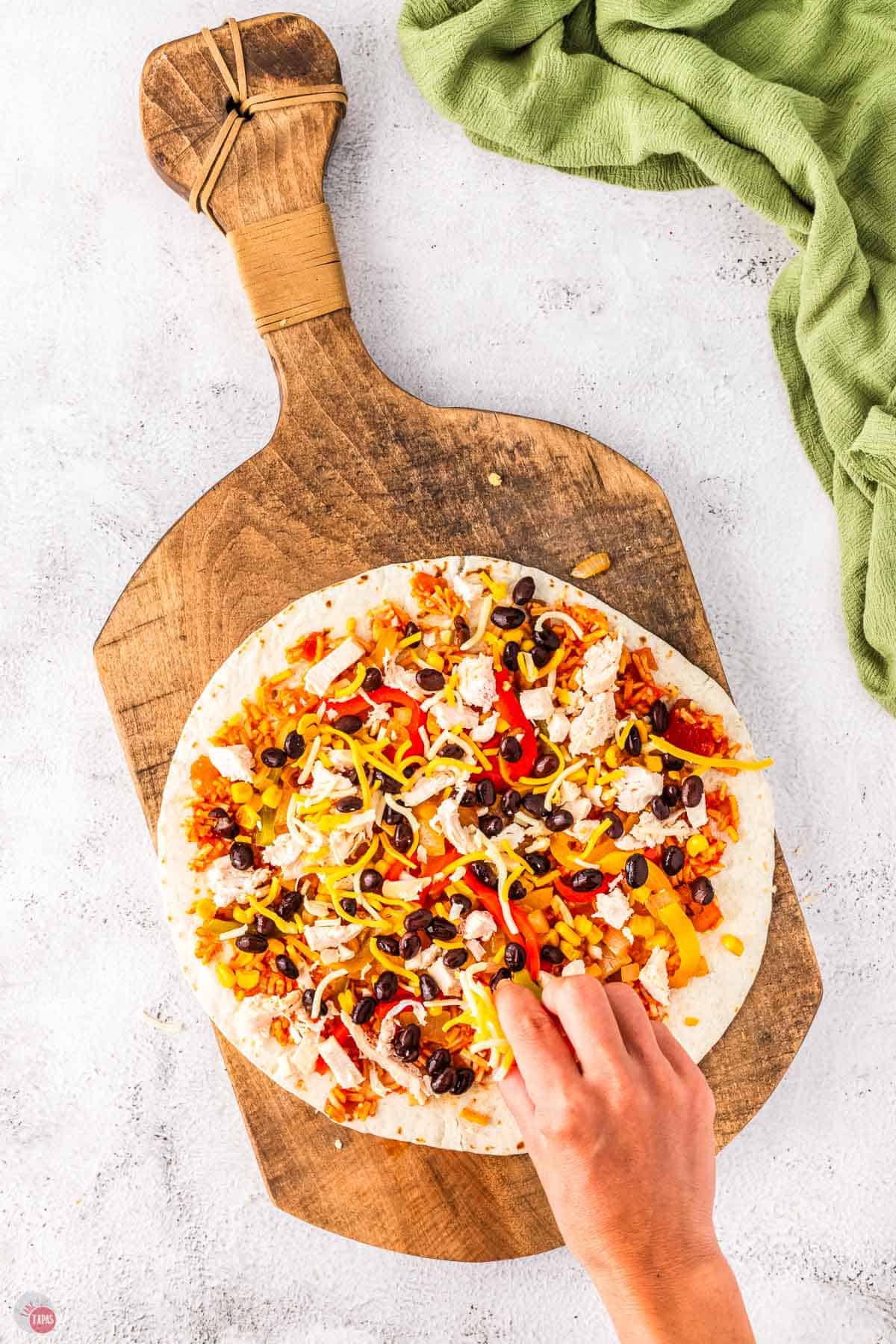flour tortilla with chicken and vegetables on it