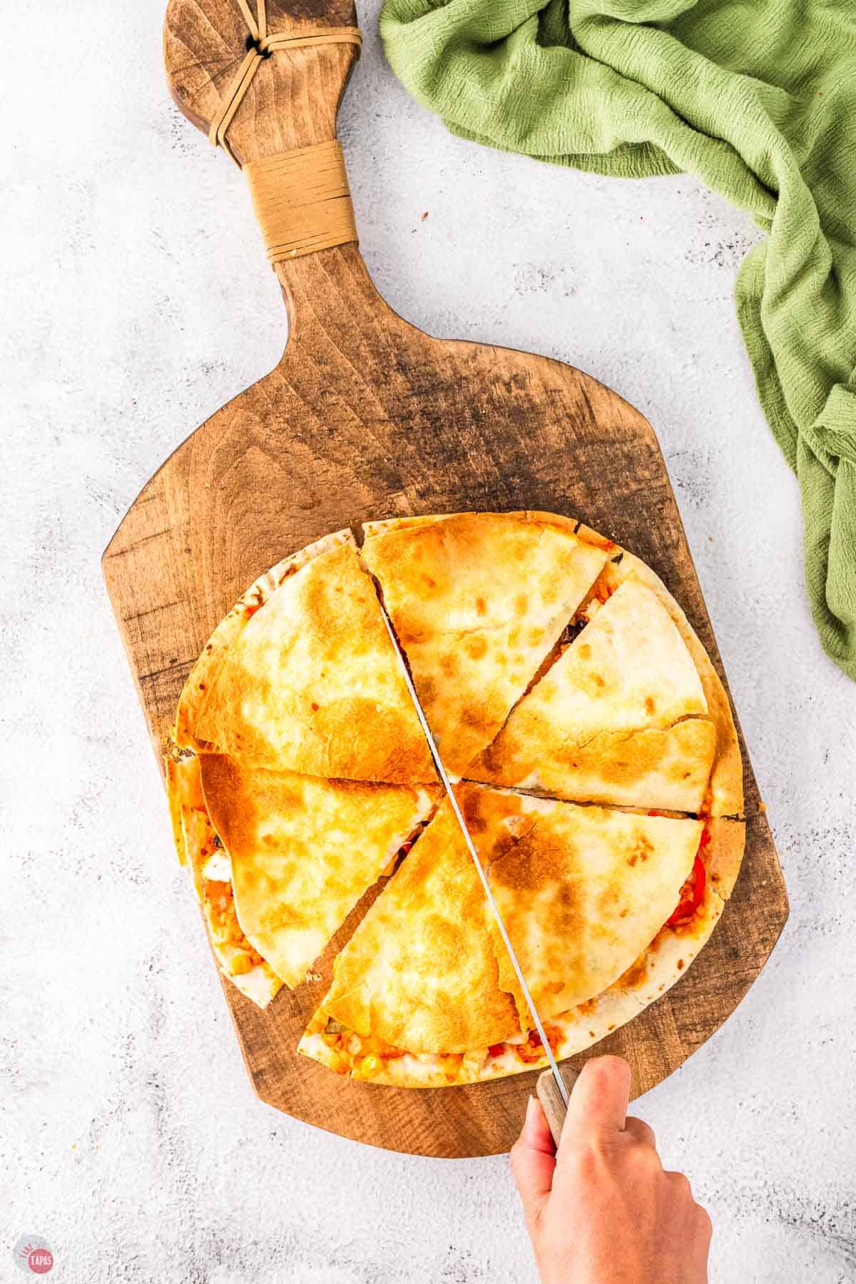 air fryer quesadilla on a wood board cut into wedges