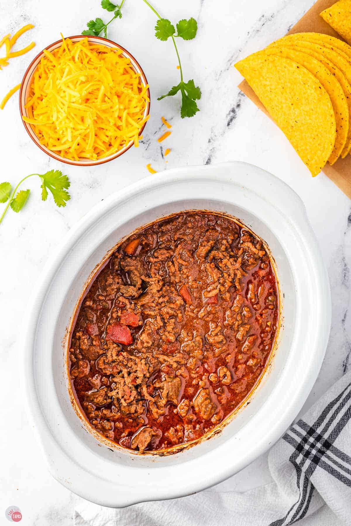 white slow cooker bowl with taco meat in it