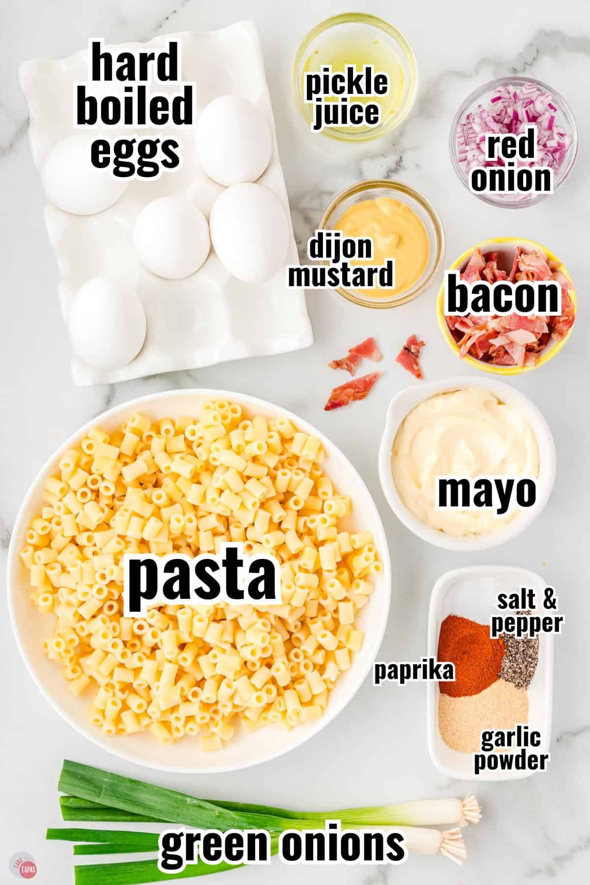 ingredients for pasta salad recipe in individual bowls with text overlay labeling them