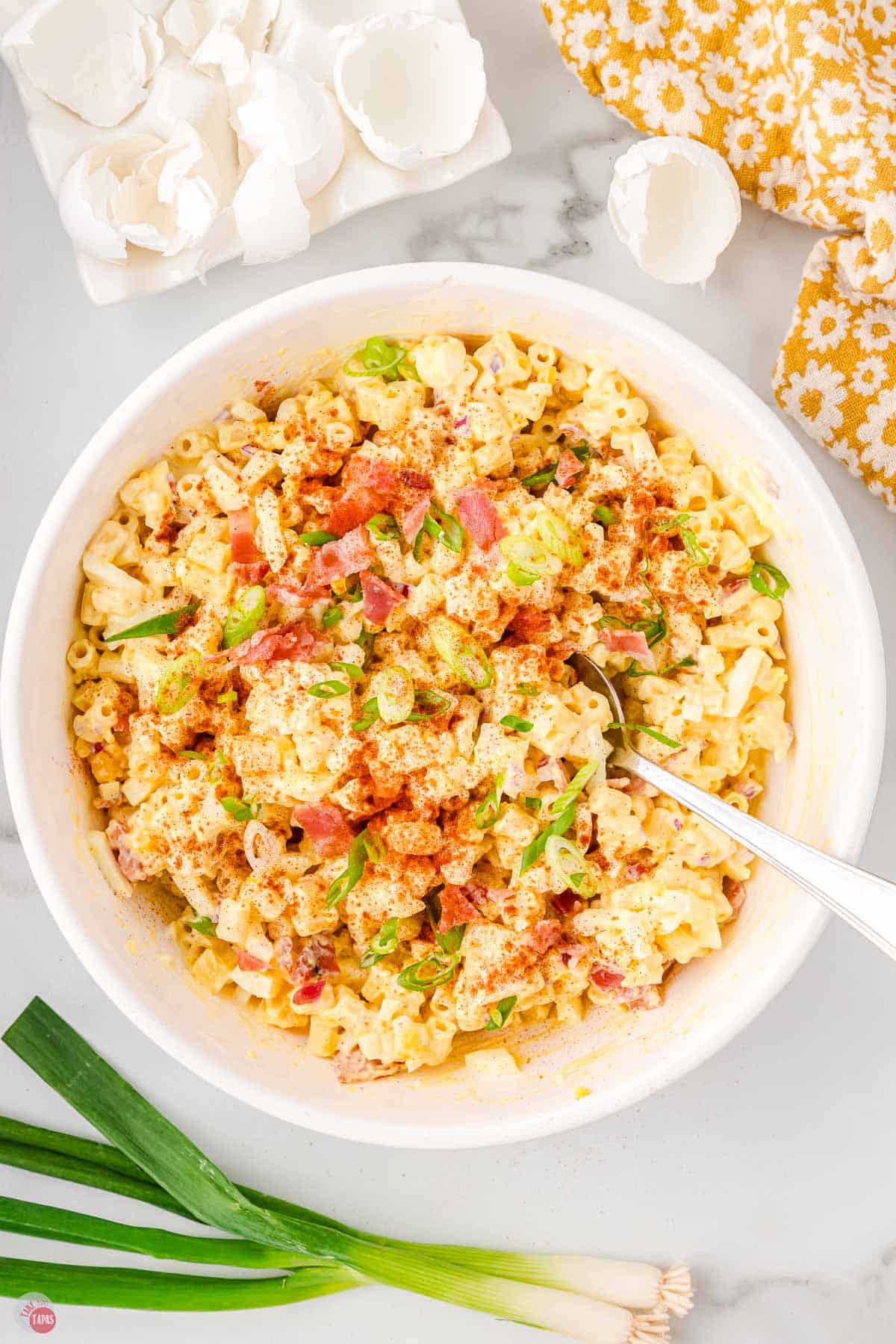 deviled egg pasta salad garnished with paprika in a white bowl