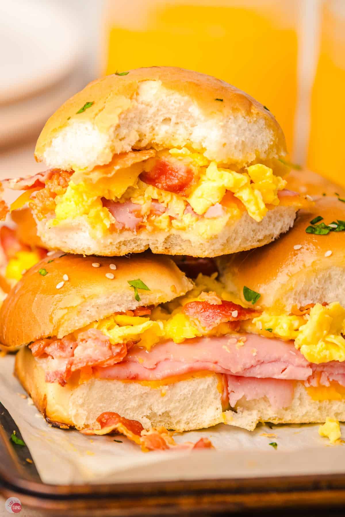 close up of stack of breakfast sliders on a baking sheet