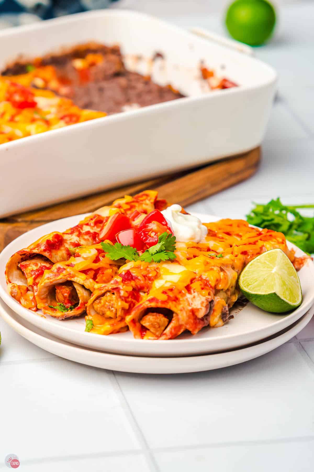 close up of enchiladas on a stack of white plates