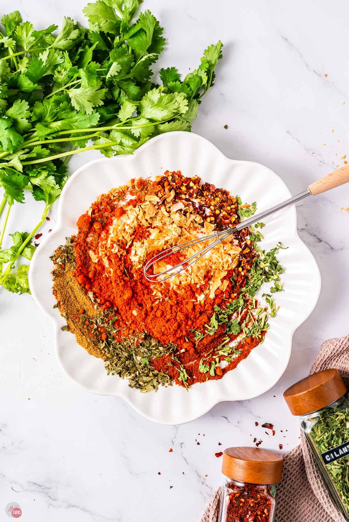 white plate with spices on it and a small whisk