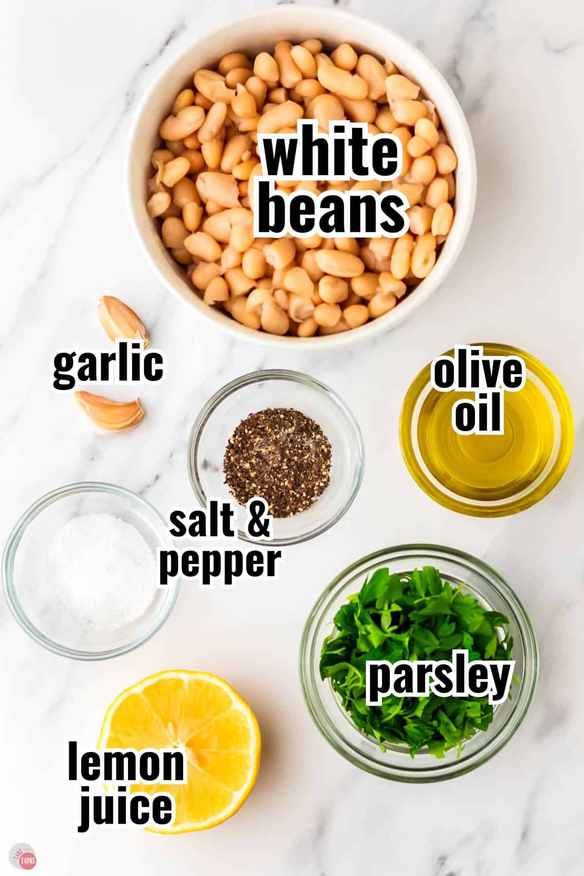 ingredients for hummus in individual bowls with text overlay labeling them