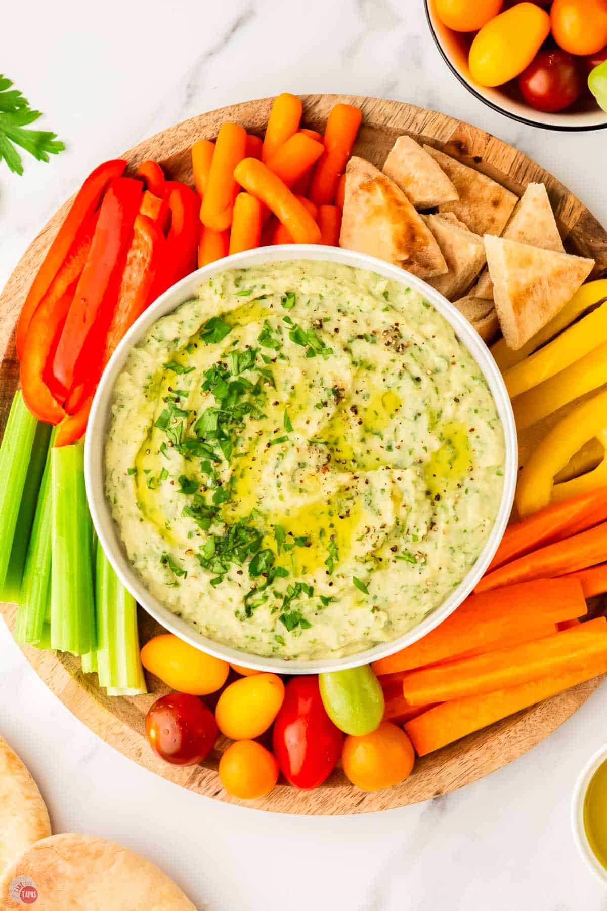 white bean hummus in a bowl surrounded by vegetables