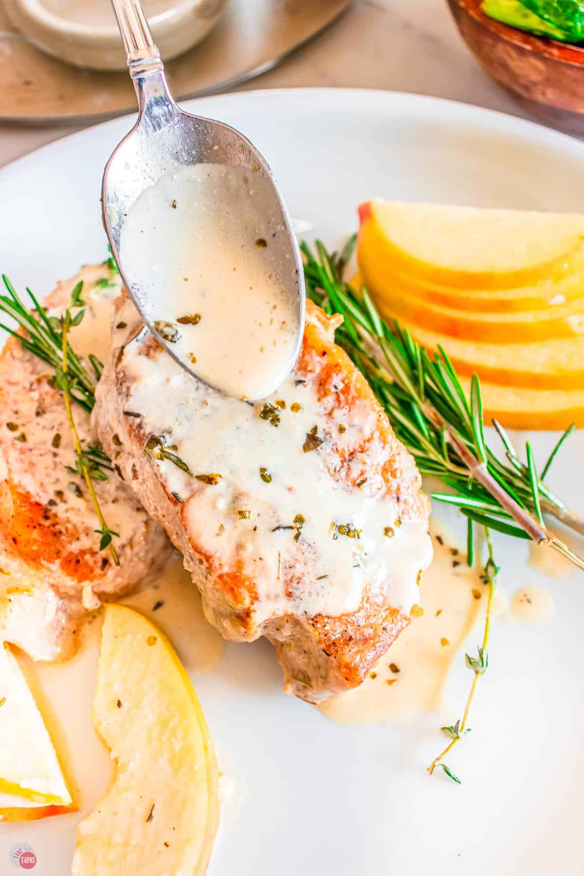 pork chop with sauce being spooned over it