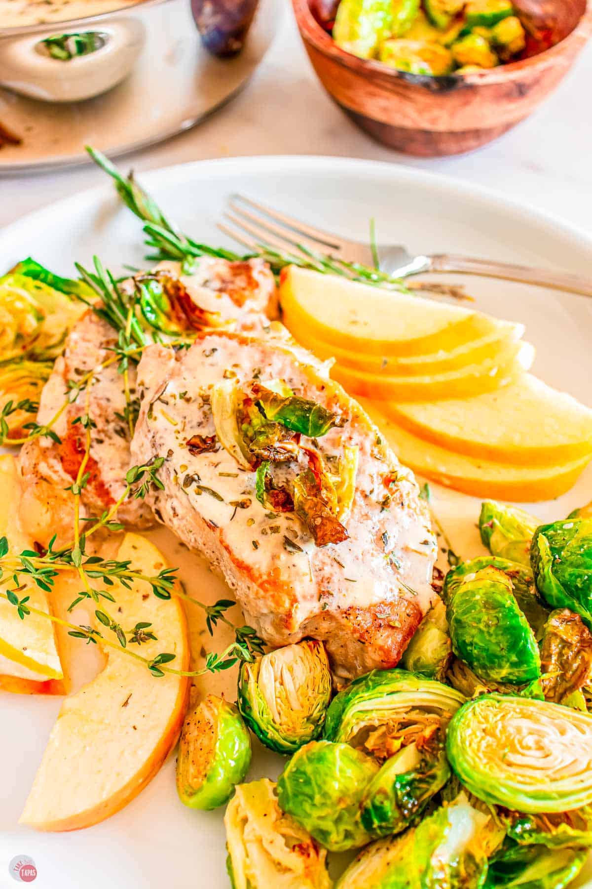 plate of apple cider pork chops with apples and brussel sprouts