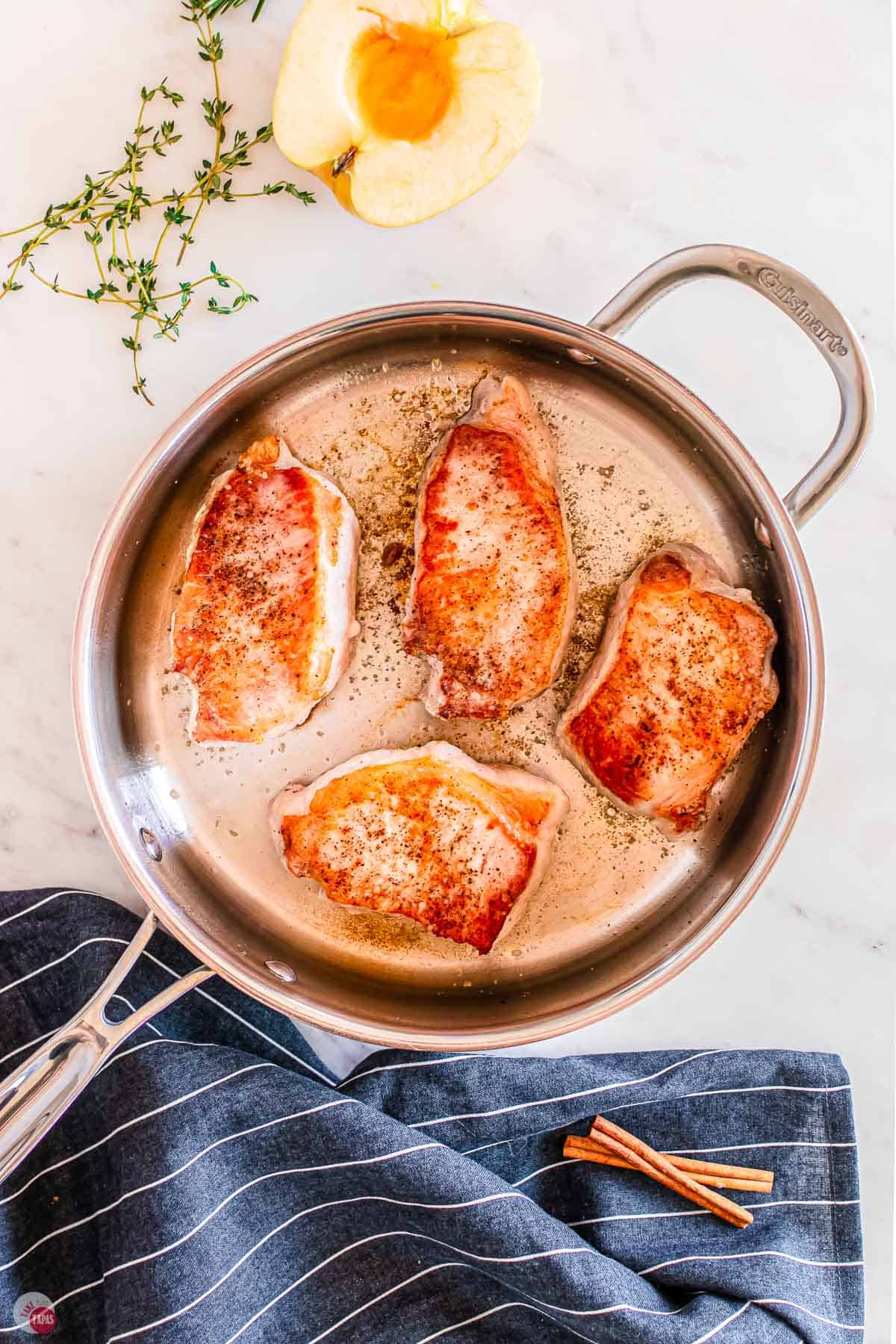 pork chops cooking in a skillet