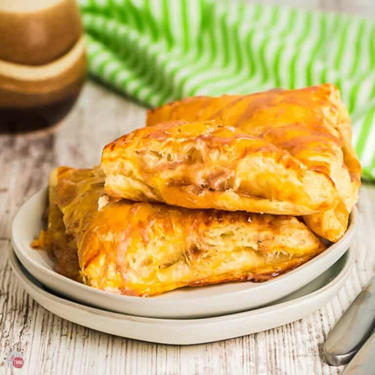 two plates with 3 apple turnovers on them