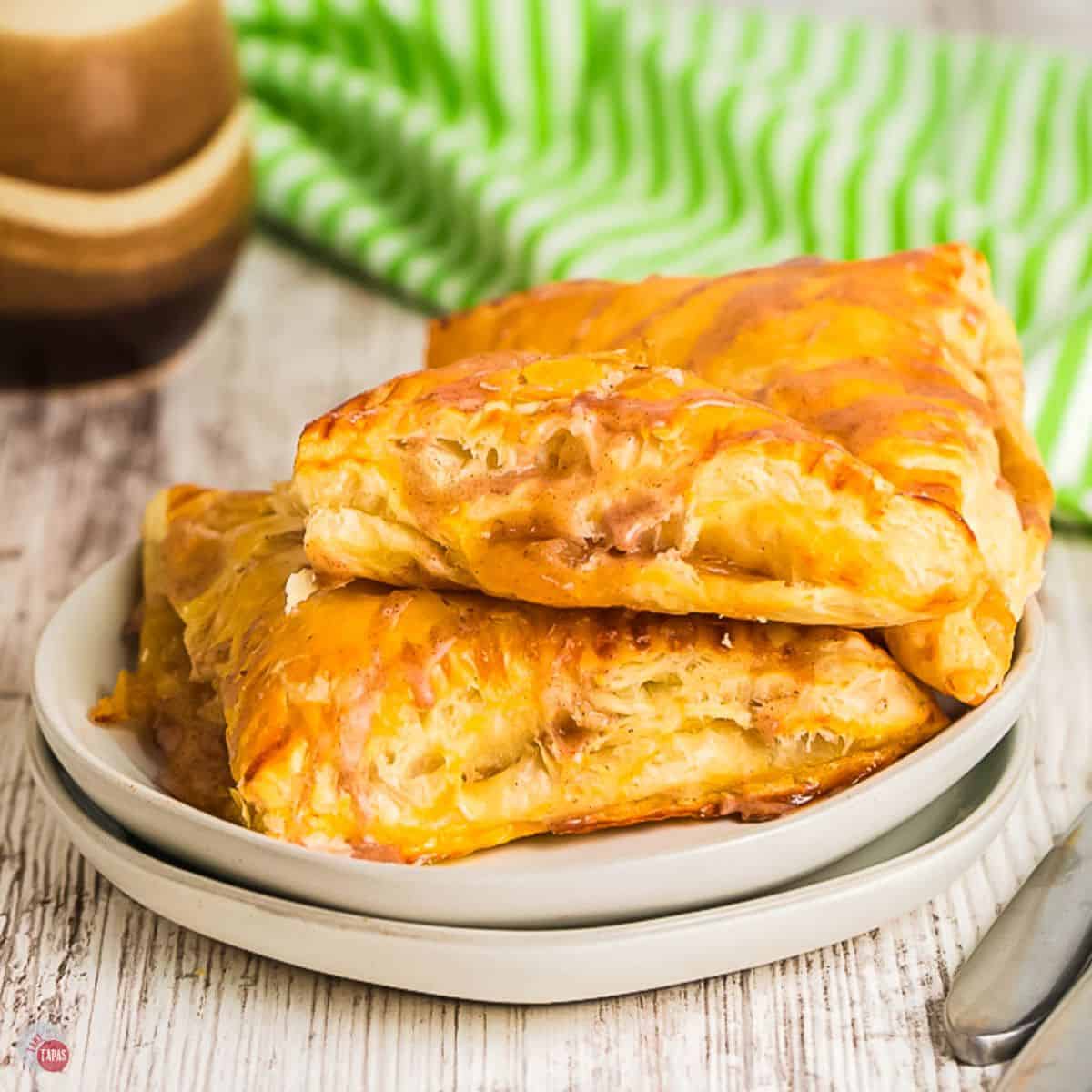two plates with 3 apple turnovers on them