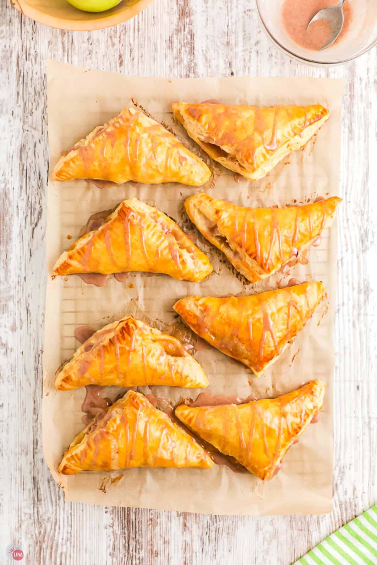 glazed puff pastry turnovers on a piece of parchment paper