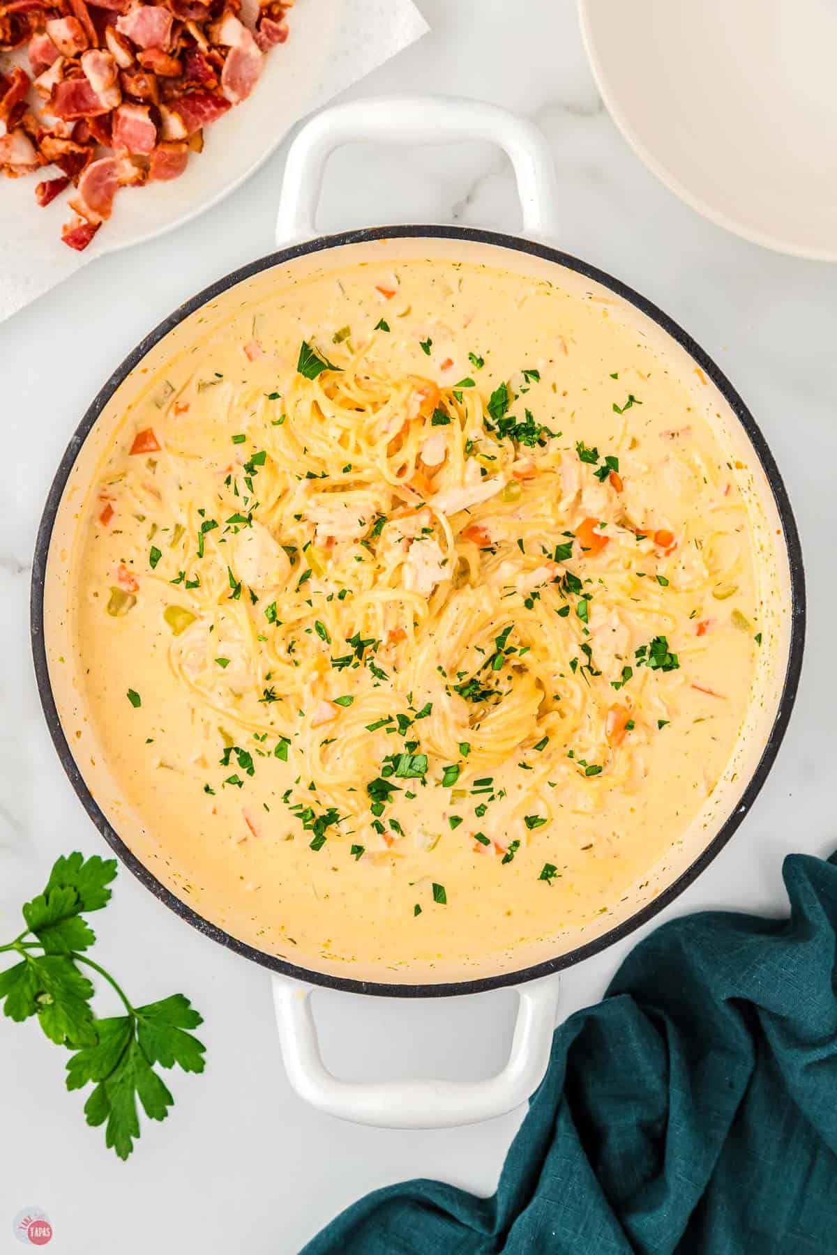 pot of creamy chicken noodle soup with parsley on top