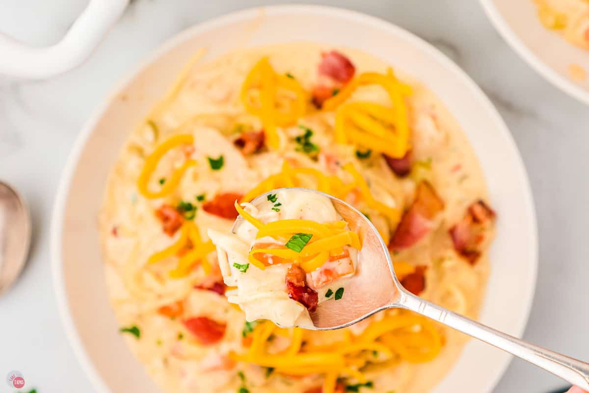 spoon holding a bite of soup over a bowl