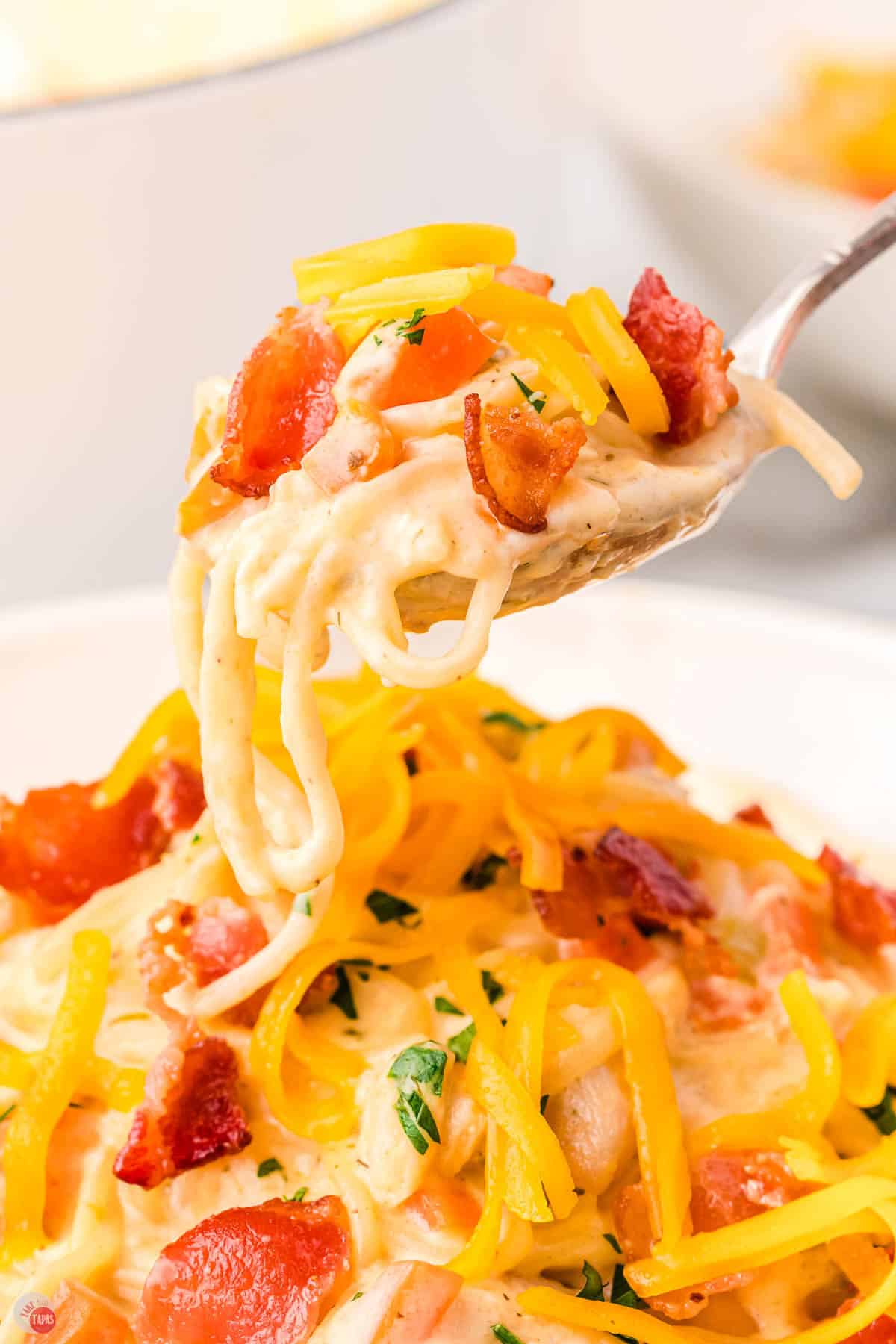 close up of noodle soup with bacon and cheese