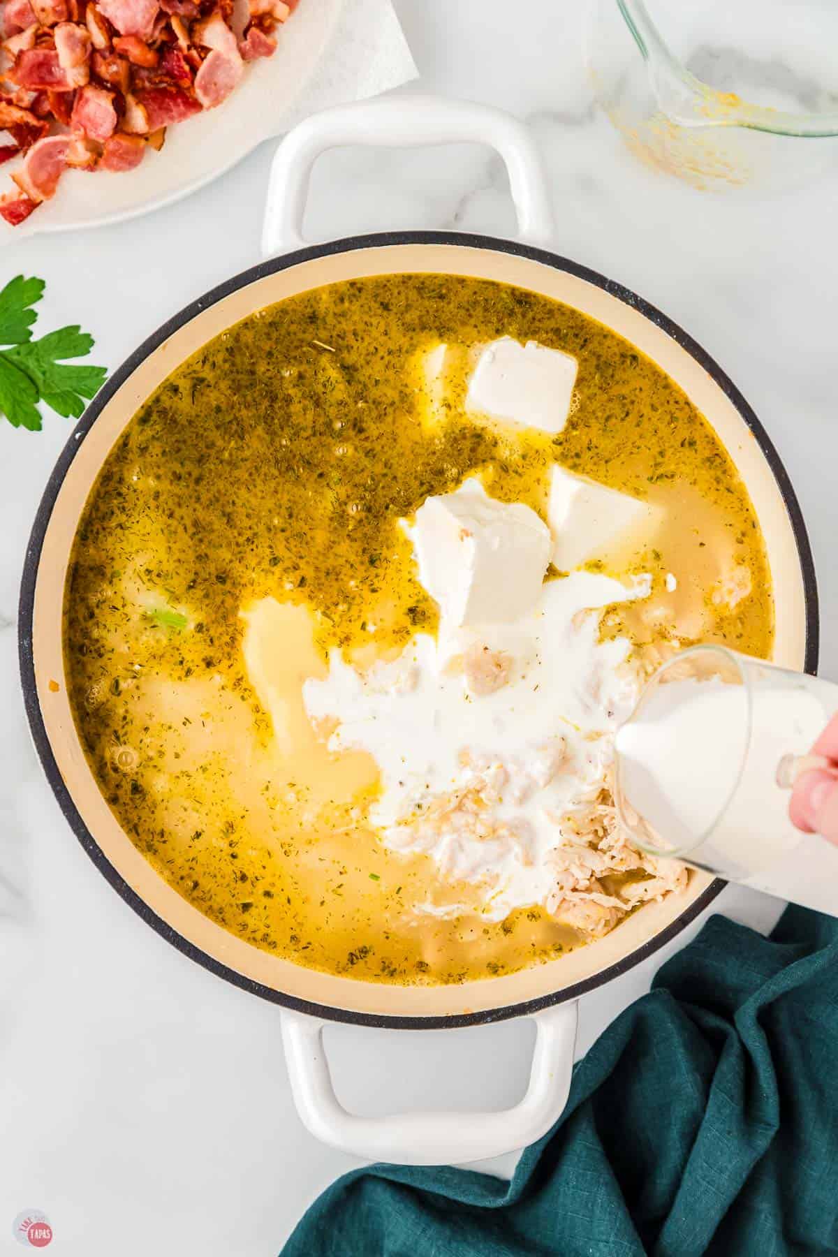 soup pot with cream being poured in