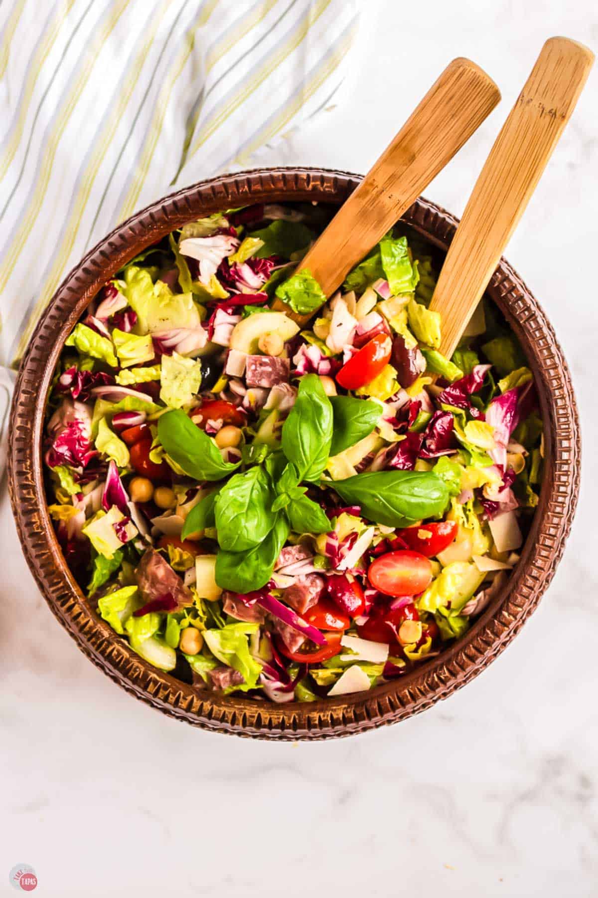 bowl of italian chopped salad with two wood spoons