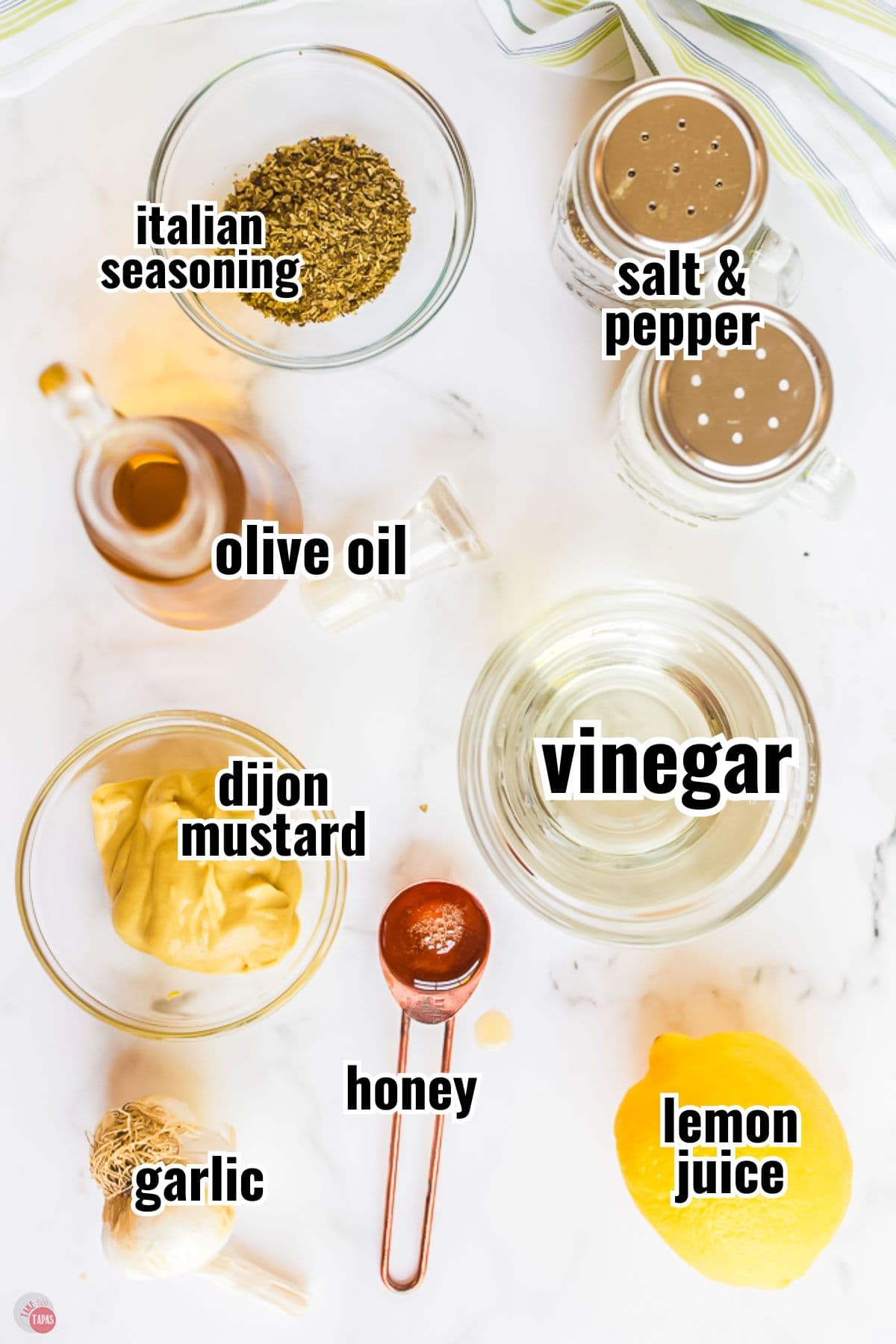 ingredients for a salad dressing in individual bowls with text overlay labeling them