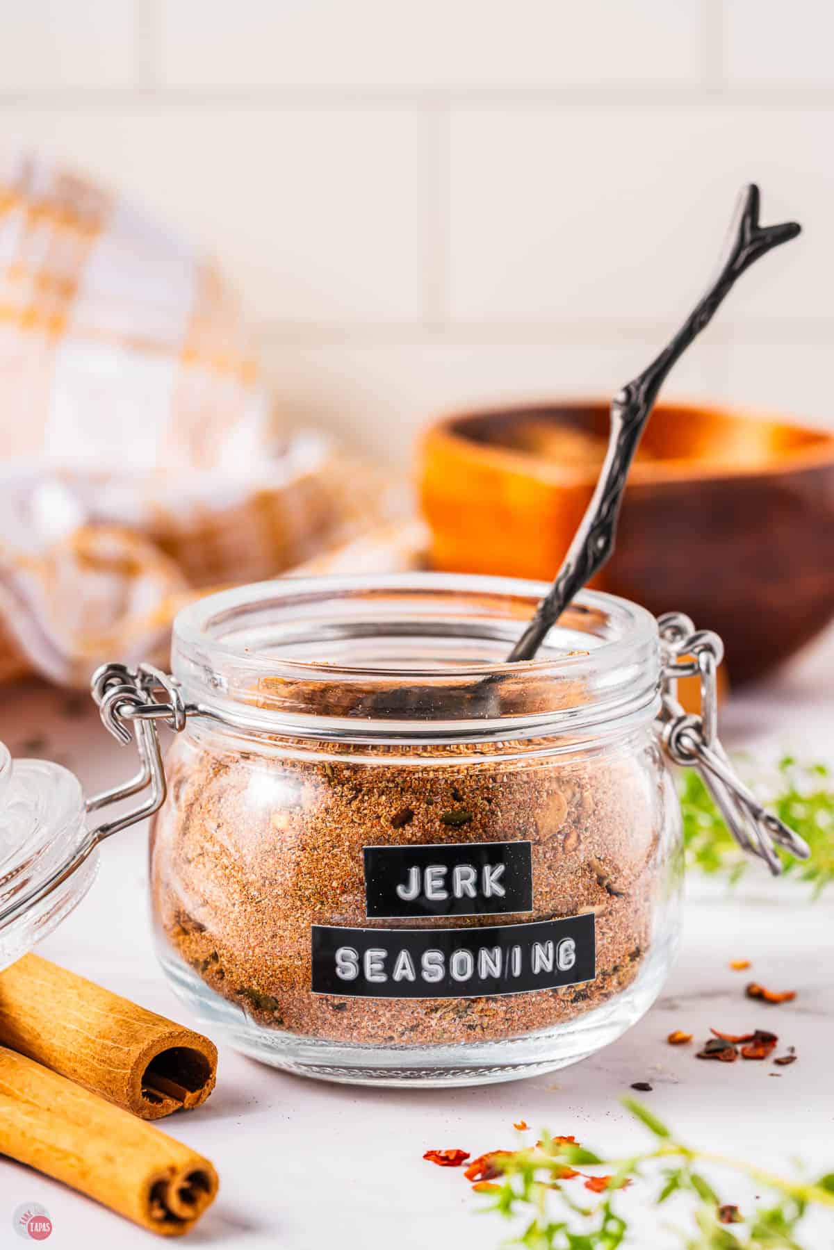 jar of jerk seasoning with a metal spoon sticking out of it