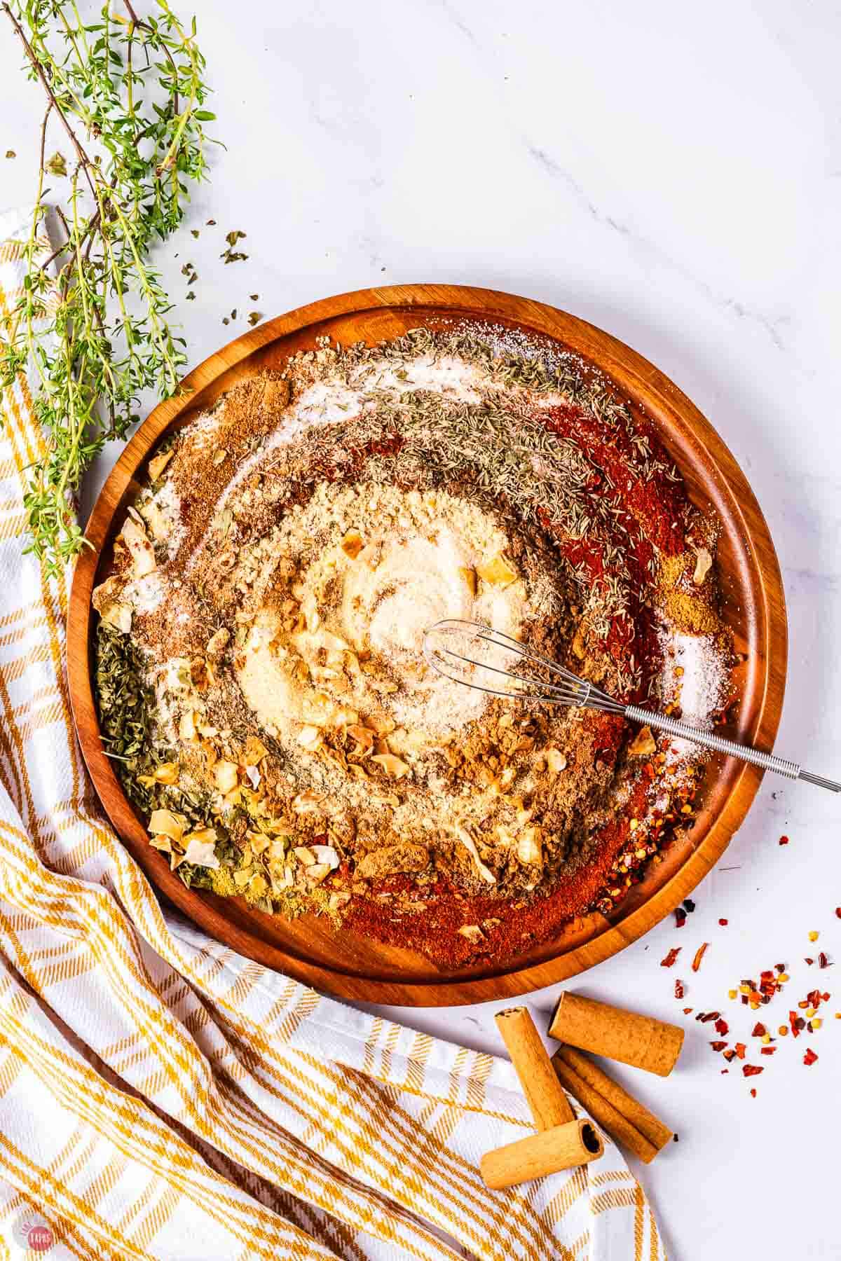 spices being mixed with a whisk on a wood plate