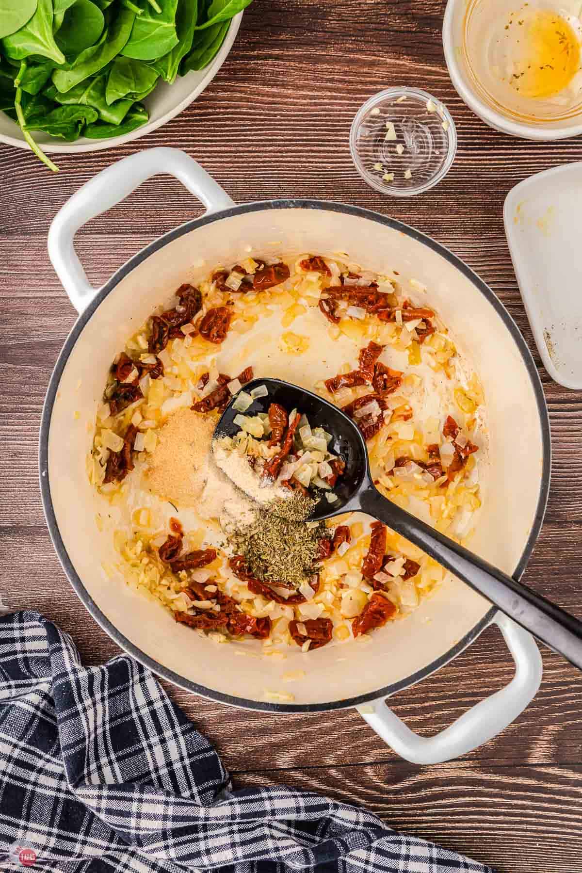 pot with onions and sun-dried tomatoes cooking