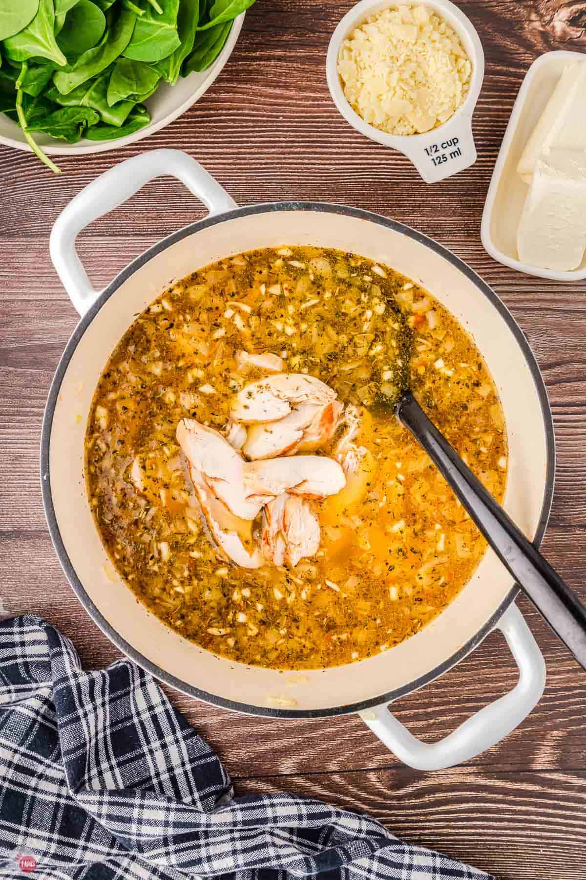 soup pot with broth and chicken in it