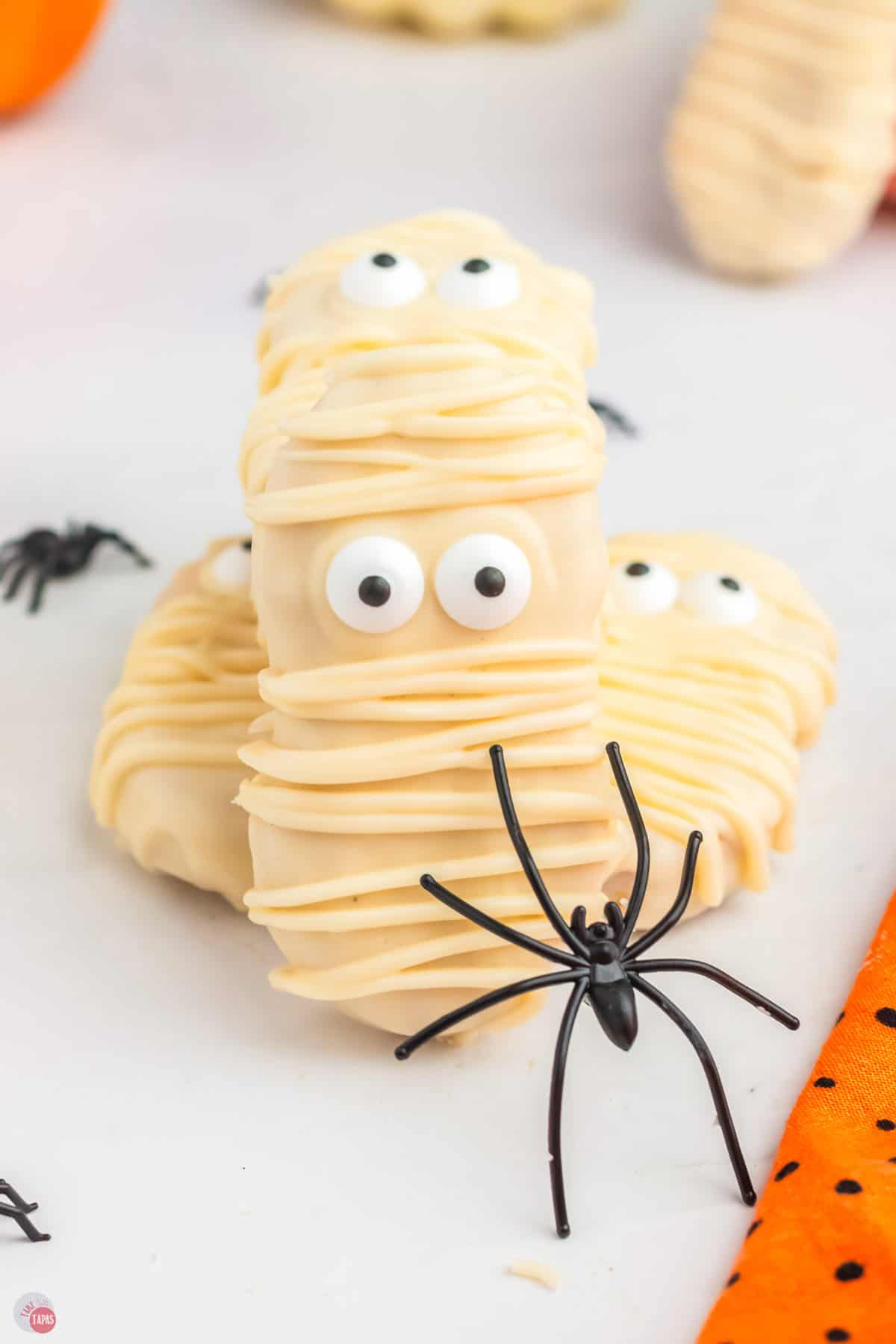 stack of 3 mummy cookies and a black spider