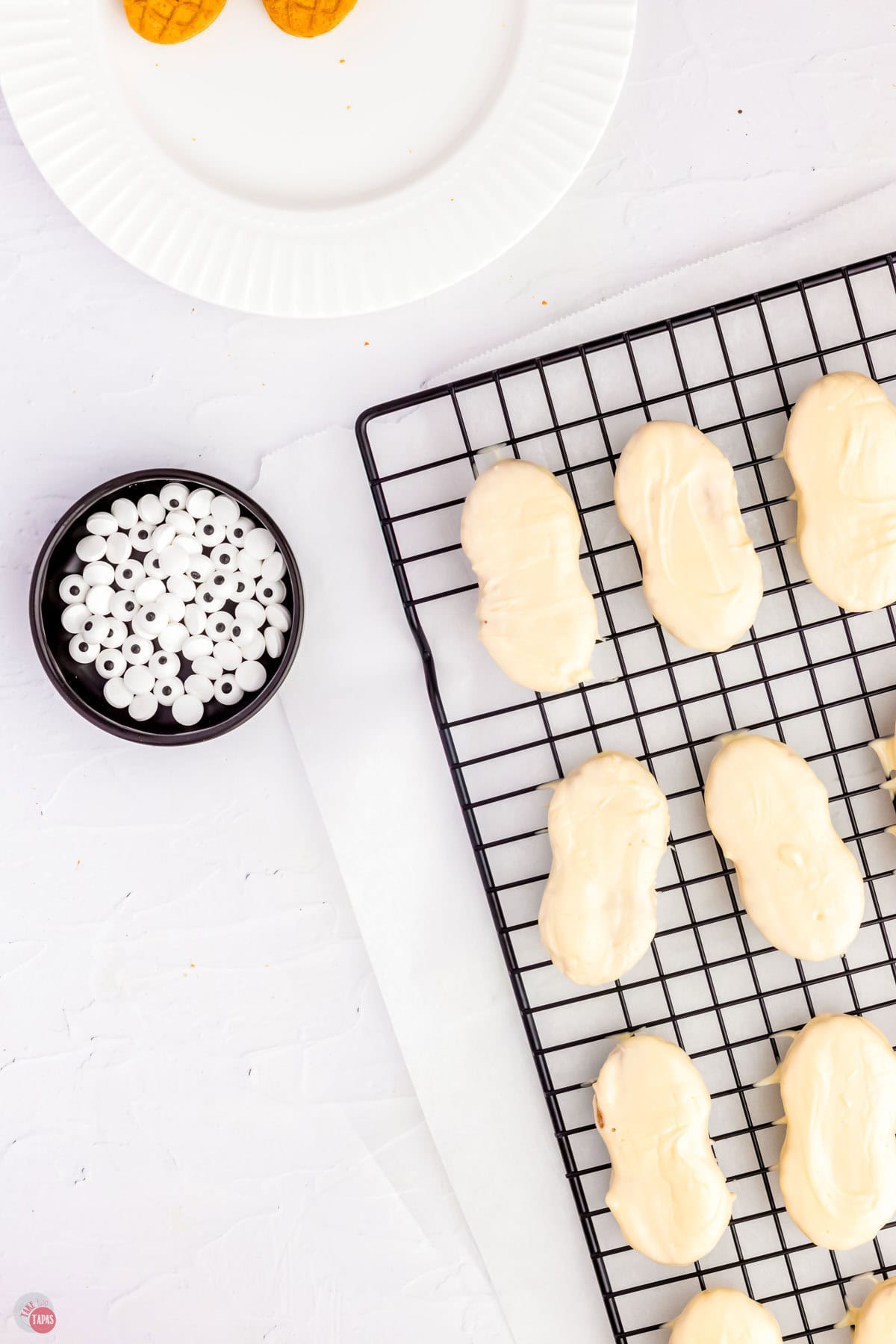 nutter butter cookies dipped in melted white chocolate on a black wire rack